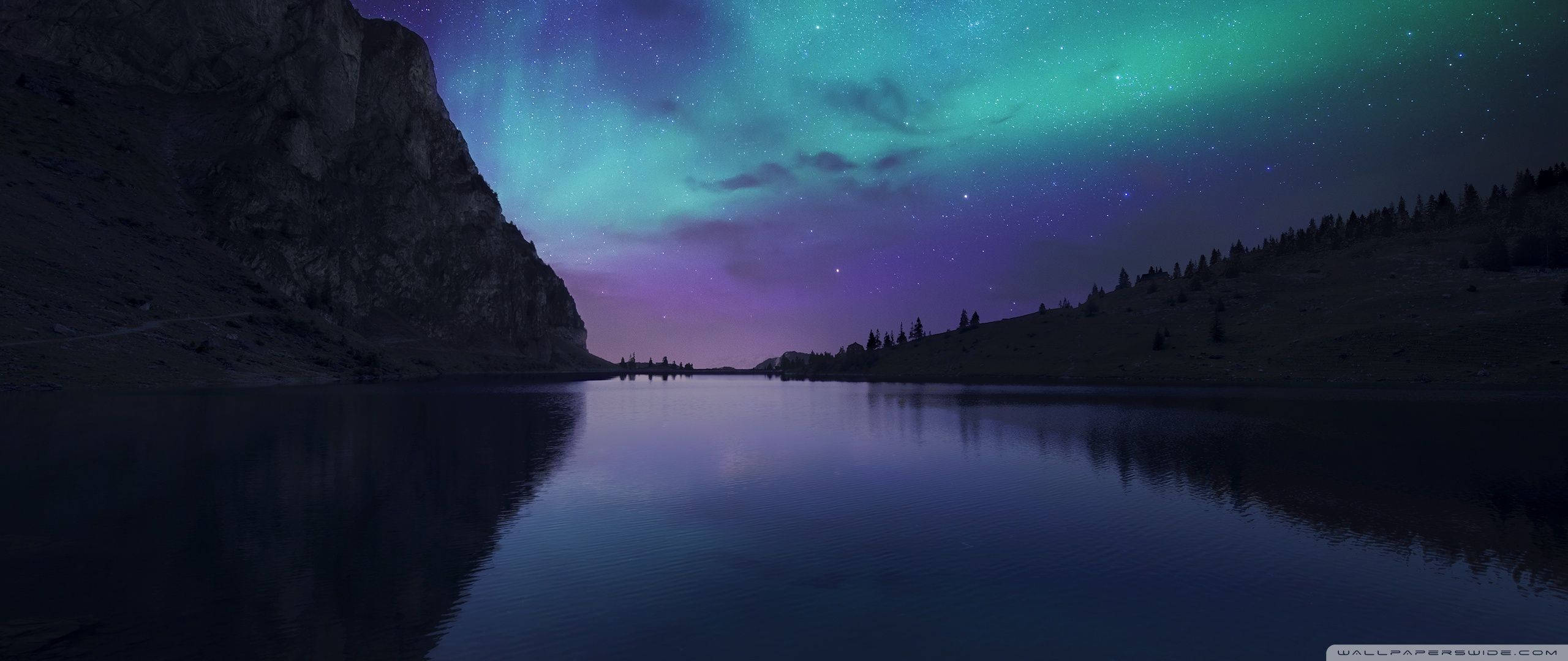 Aurora Boreală iluminează cerul întunecat de iarnă Fundal