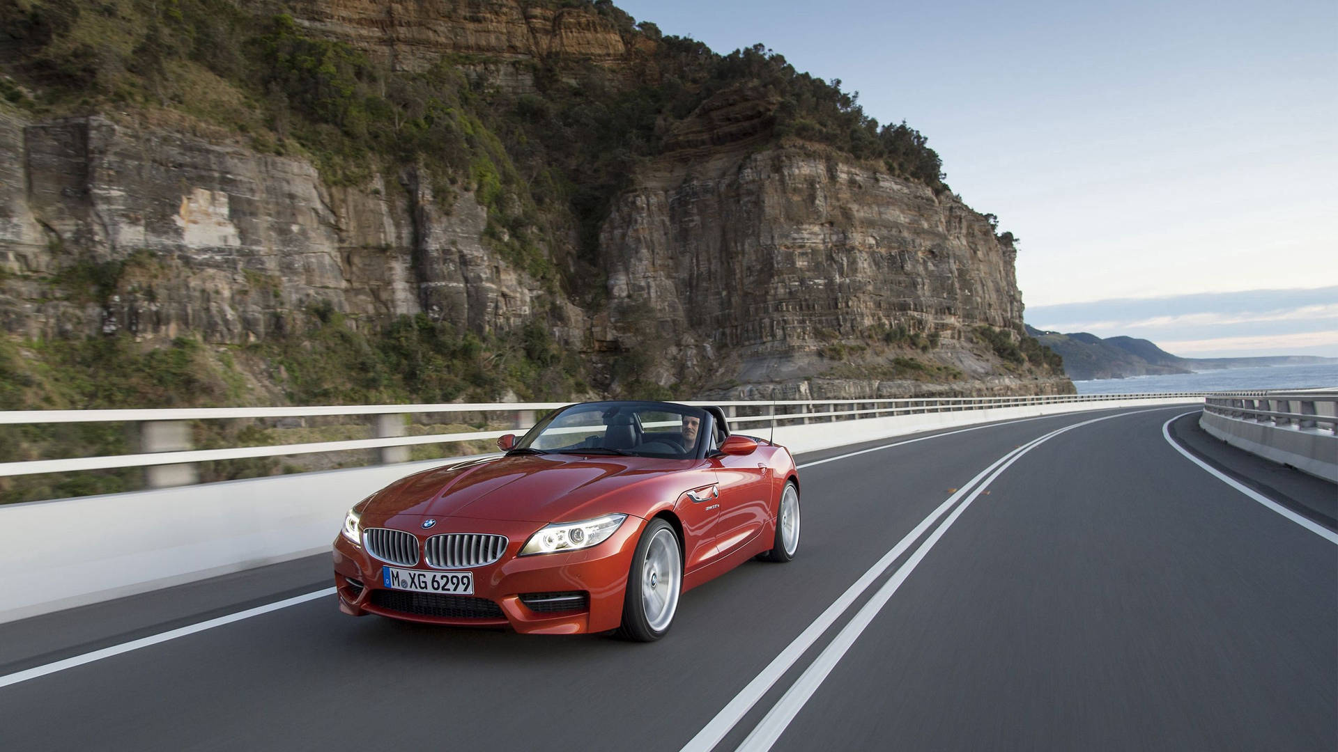 Tapet cu BMW Z4 portocaliu pe drum lângă munte — Bmw Fundal