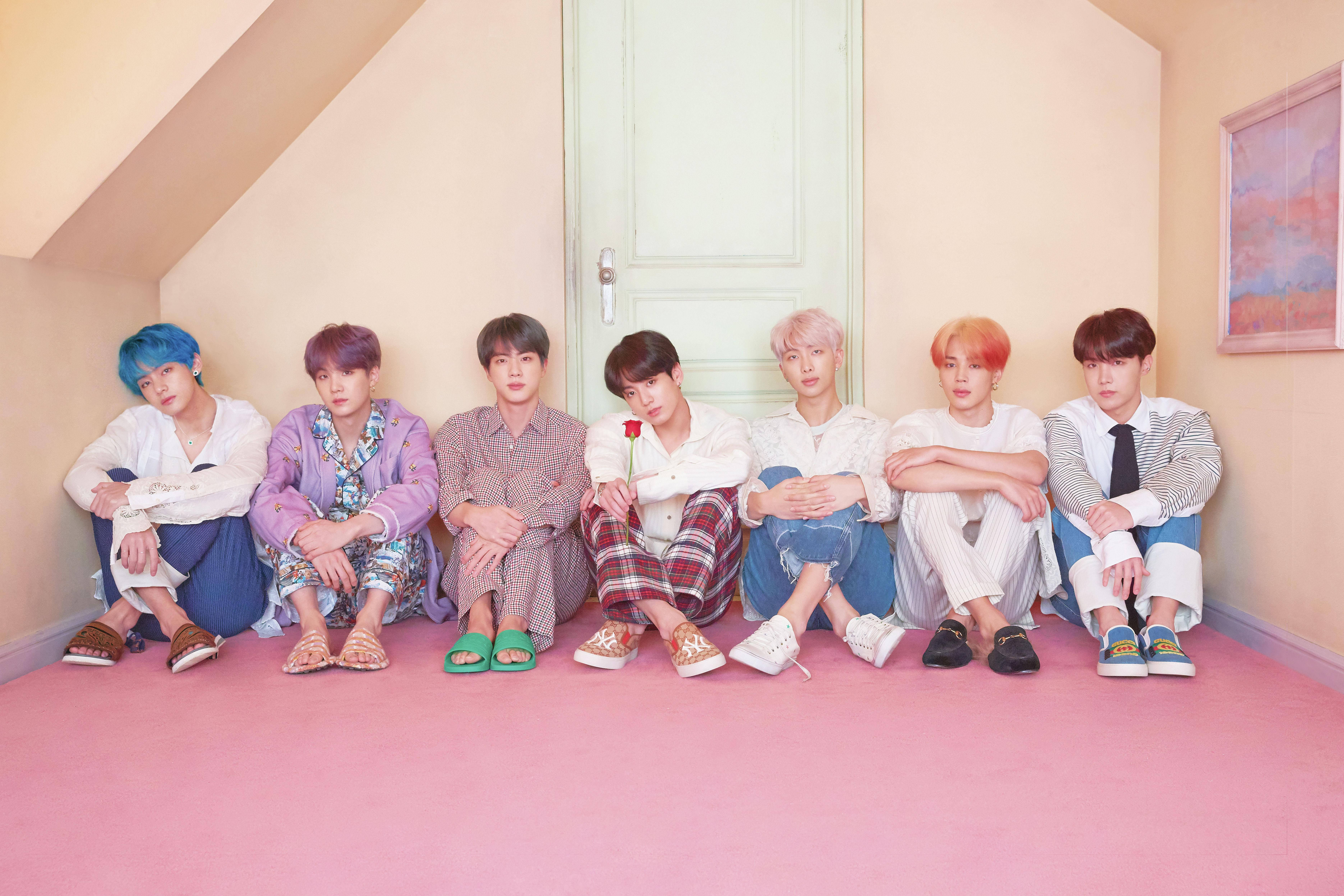 BTS pe fundal de birou, așezați în fața unei uși Fundal