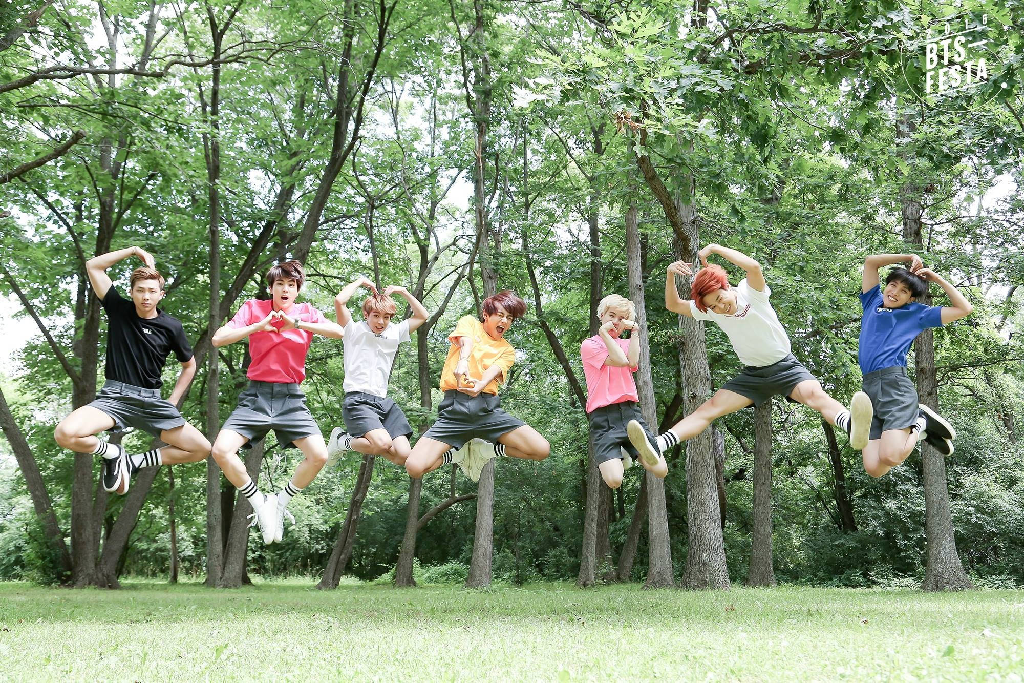 BTS Saltând în Pădure pe Fundal de Desktop Fundal