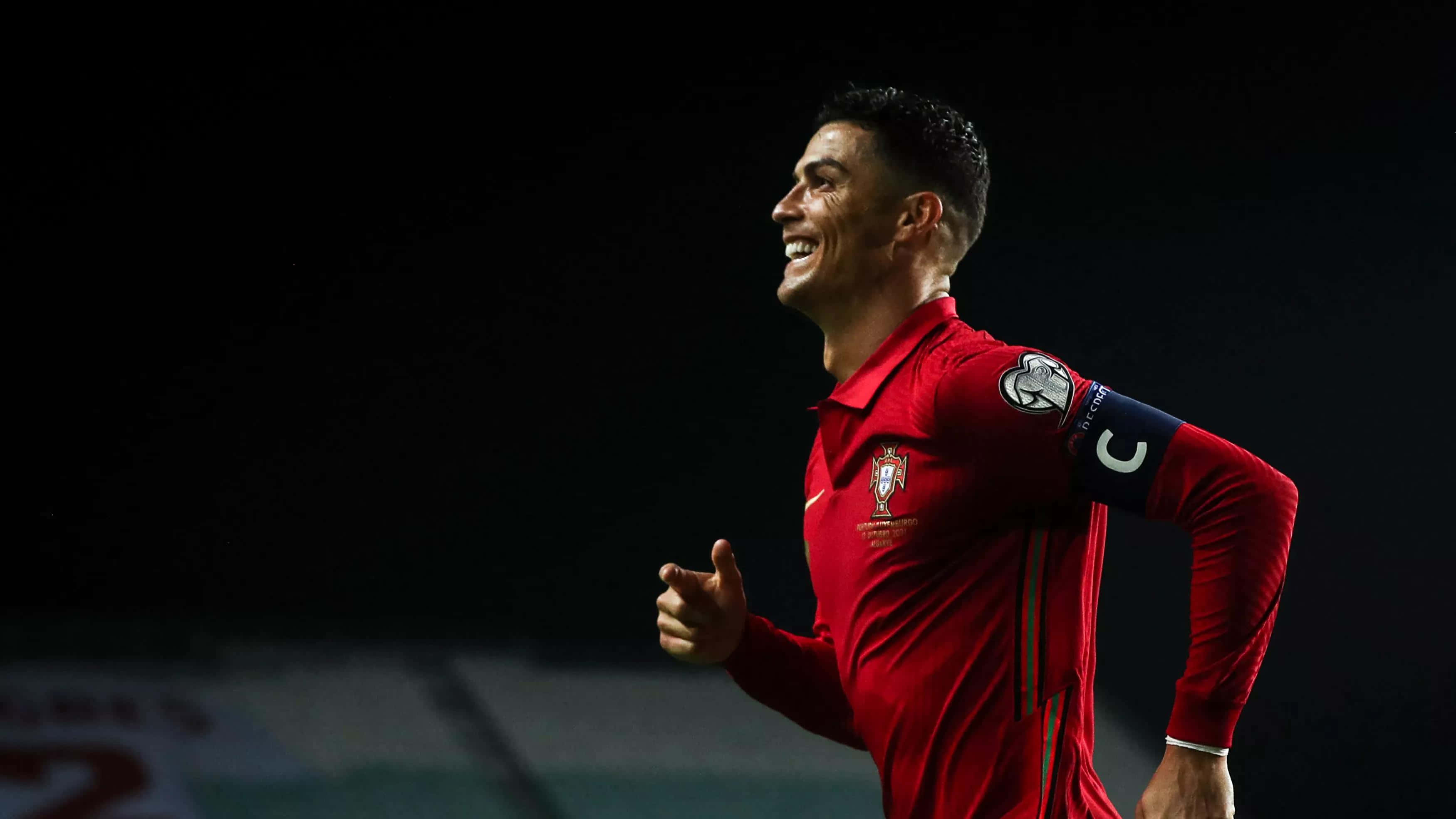 Cristiano Ronaldo alergând pe terenul de fotbal Fundal