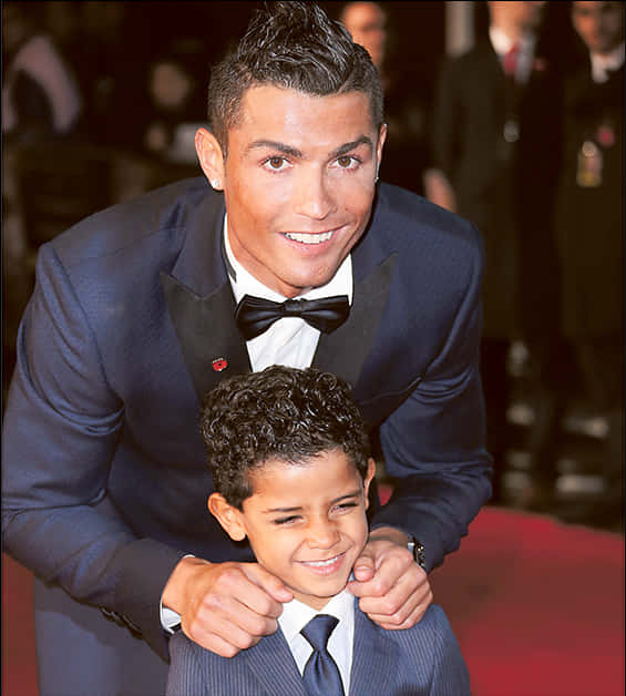 Cristiano Ronaldo zâmbind alături de un copil la un eveniment Fundal