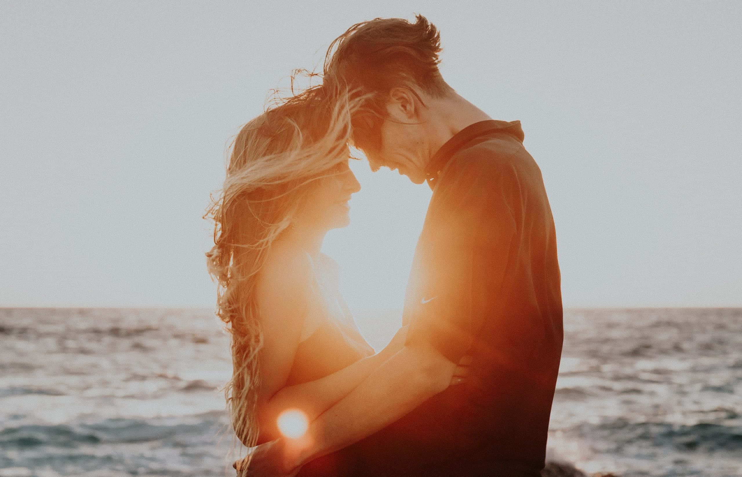 Cuplu romantic la apus într-o întâlnire pe plajă Fundal