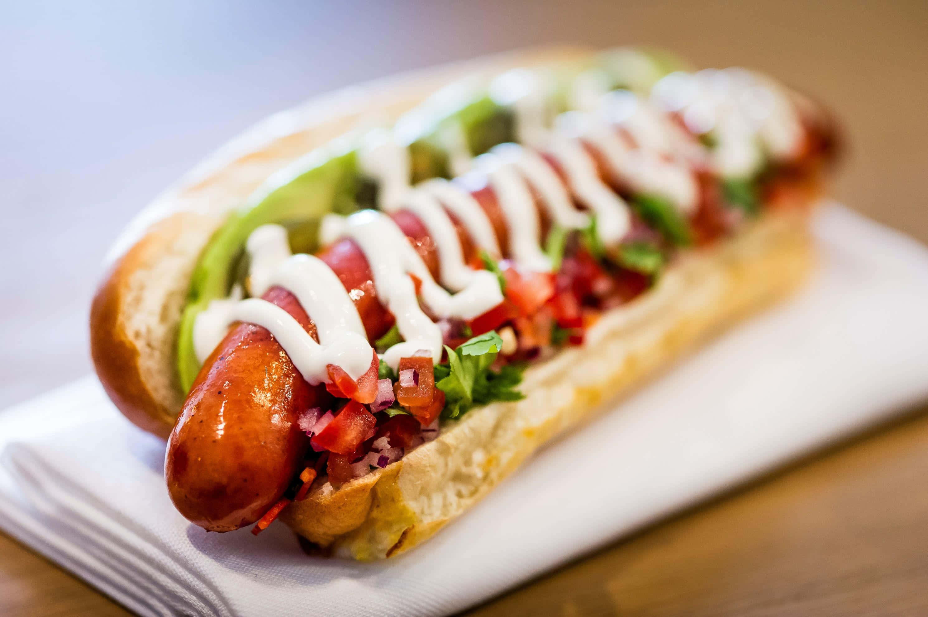 Delicios hot dog gourmet cu toppinguri proaspete Fundal