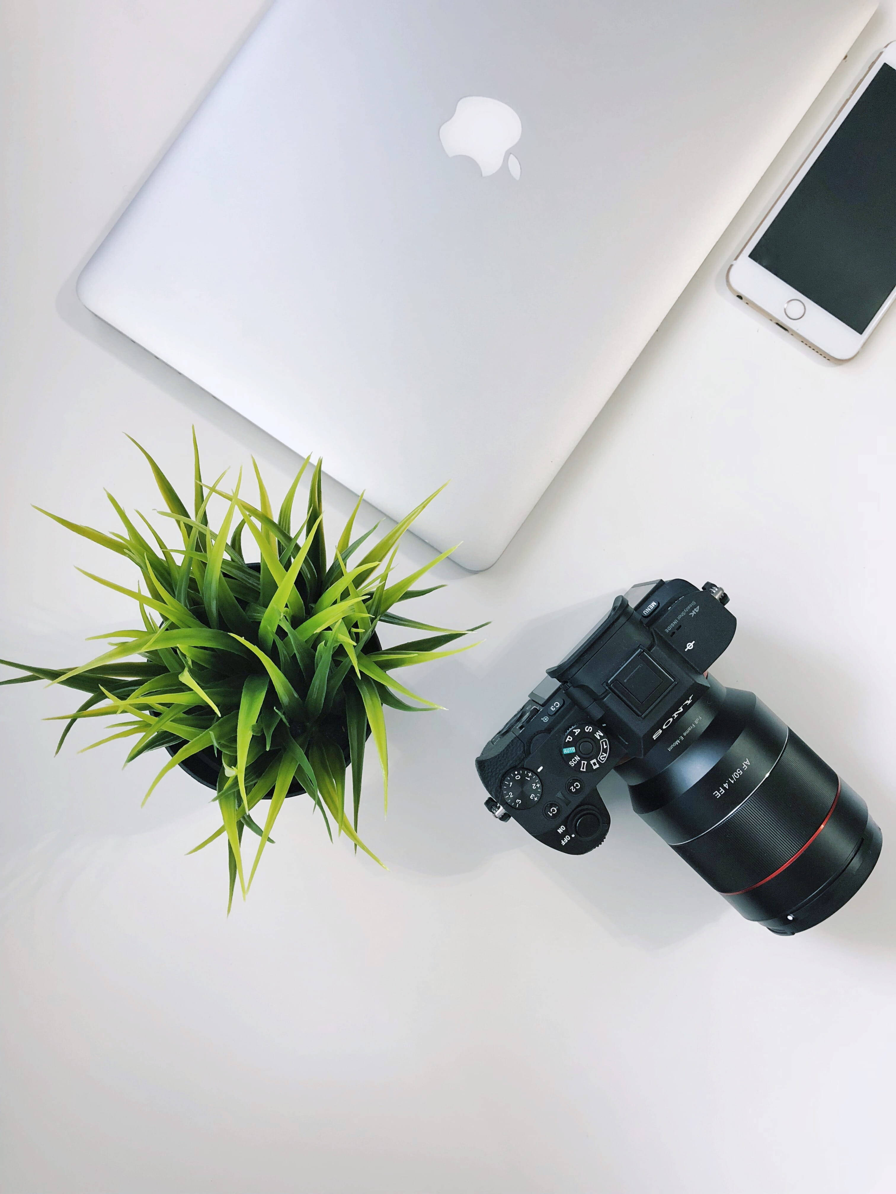 Dispozitive Apple și aparat foto pe un birou din lemn Fundal
