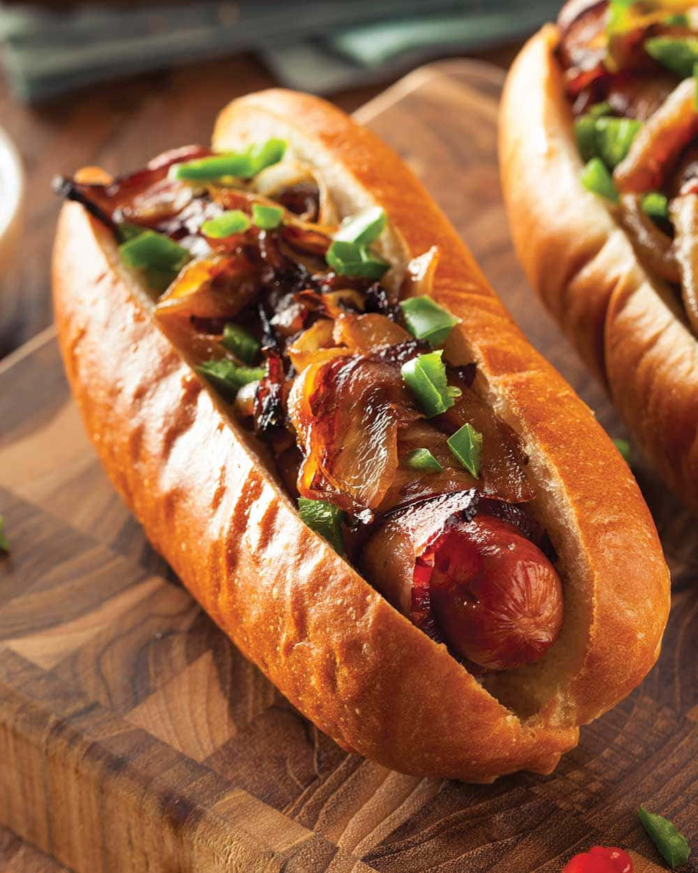 doi hot-dog-uri cu ceapă și bacon pe un fund de lemn Fundal