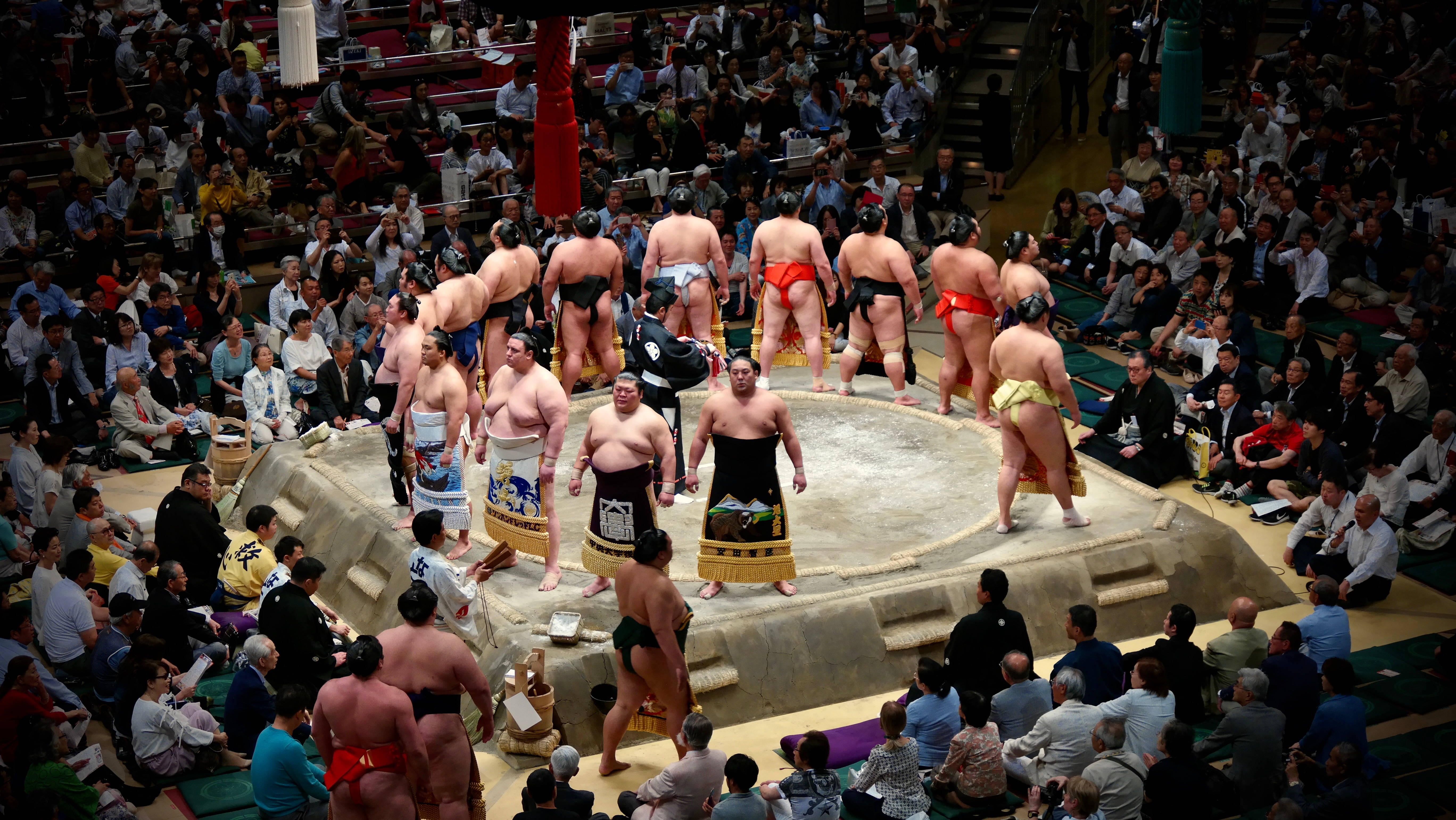 Doi luptători sumo se confruntă într-o arenă tradițională japoneză Fundal