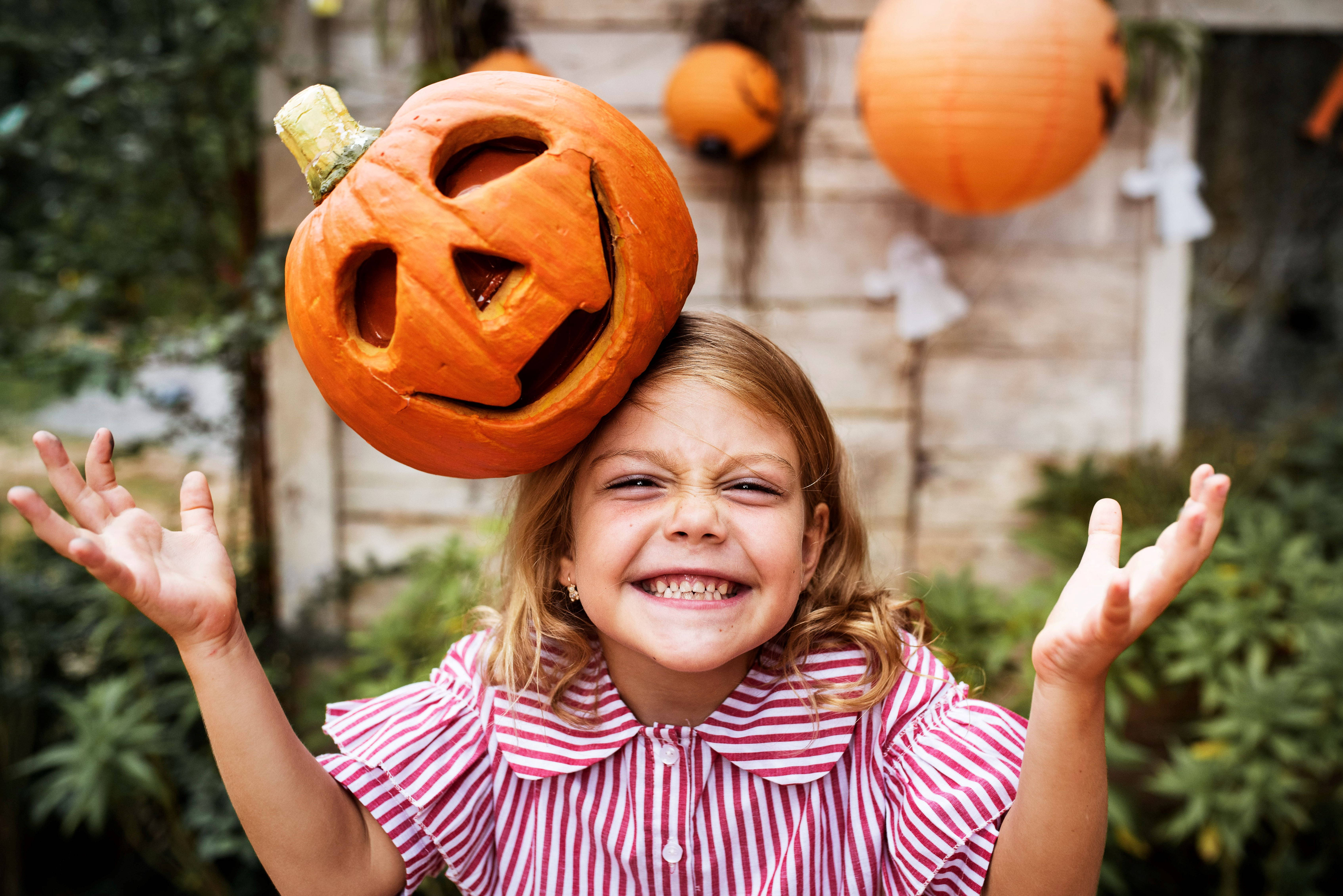 Dovleac de Halloween drăguț pe capul unei fete Fundal