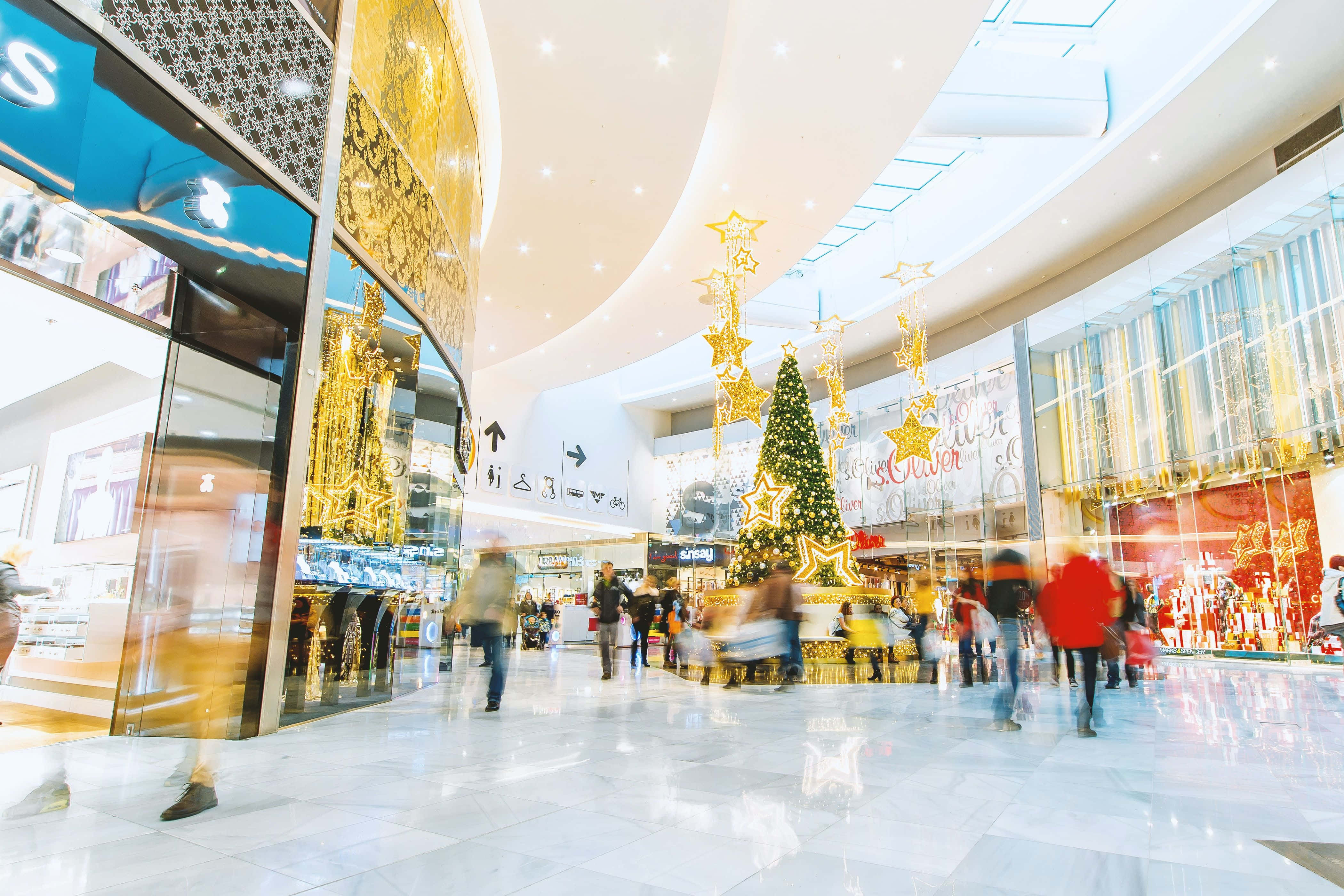 Explorează gama vibrantă de magazine și restaurante într-un mall urban Fundal