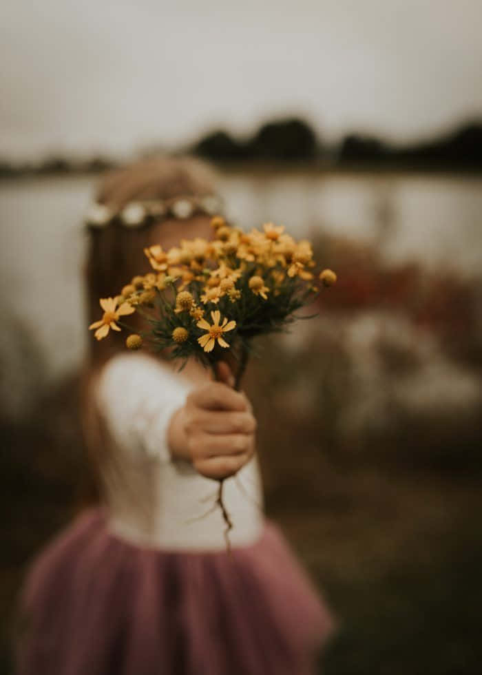 Fată emoționată ținând flori galbene Fundal