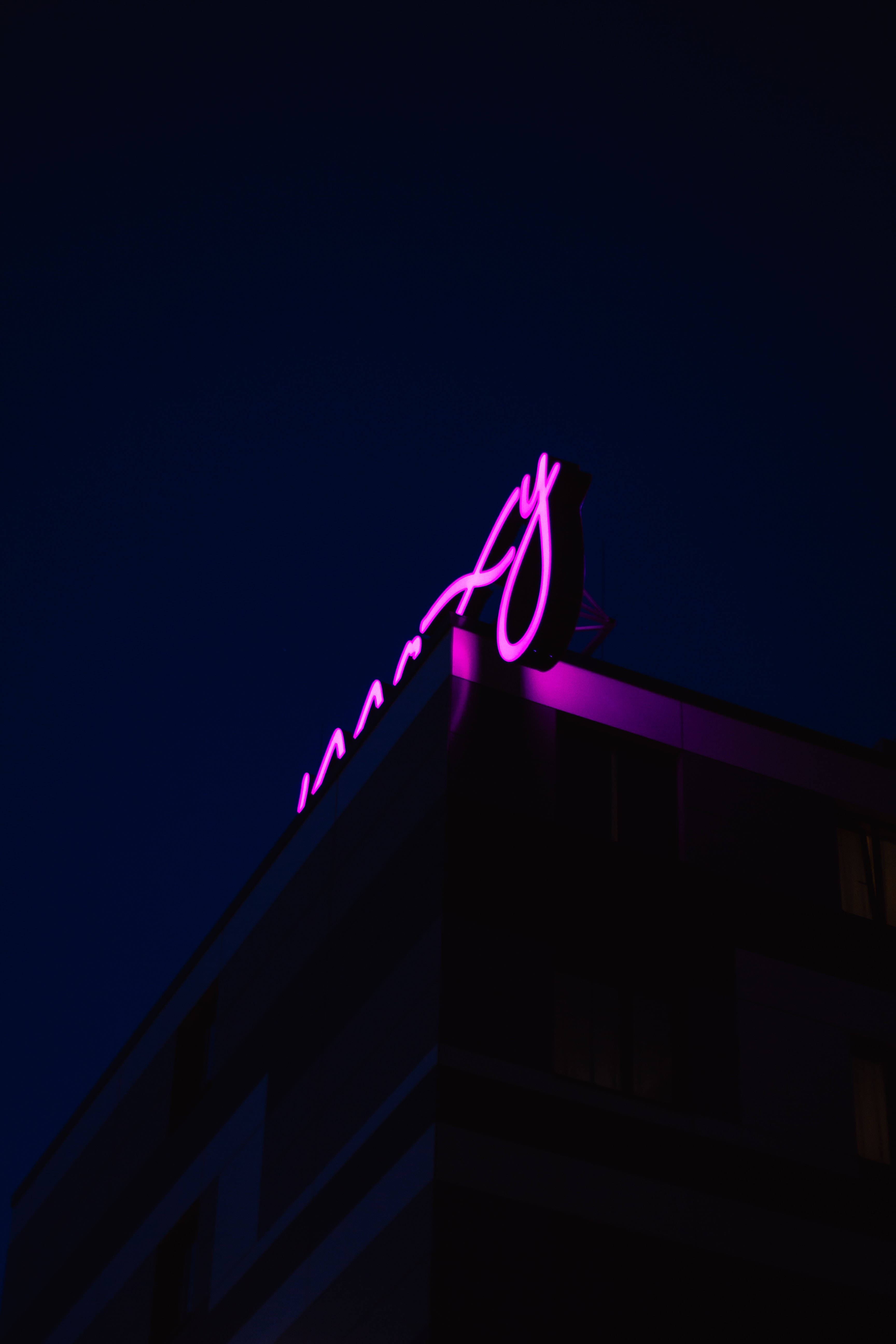 Inscripție cu neon mov pe acoperiș Fundal