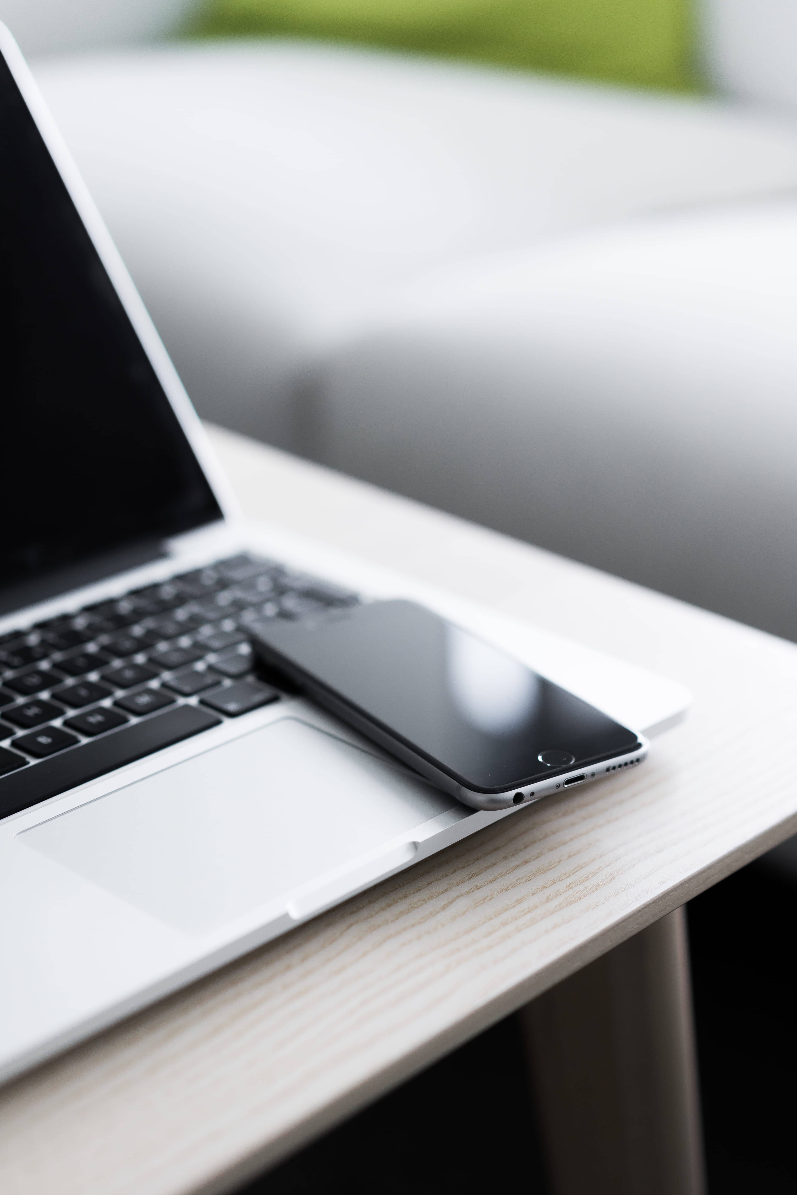 iPhone pe birou cu MacBook Fundal