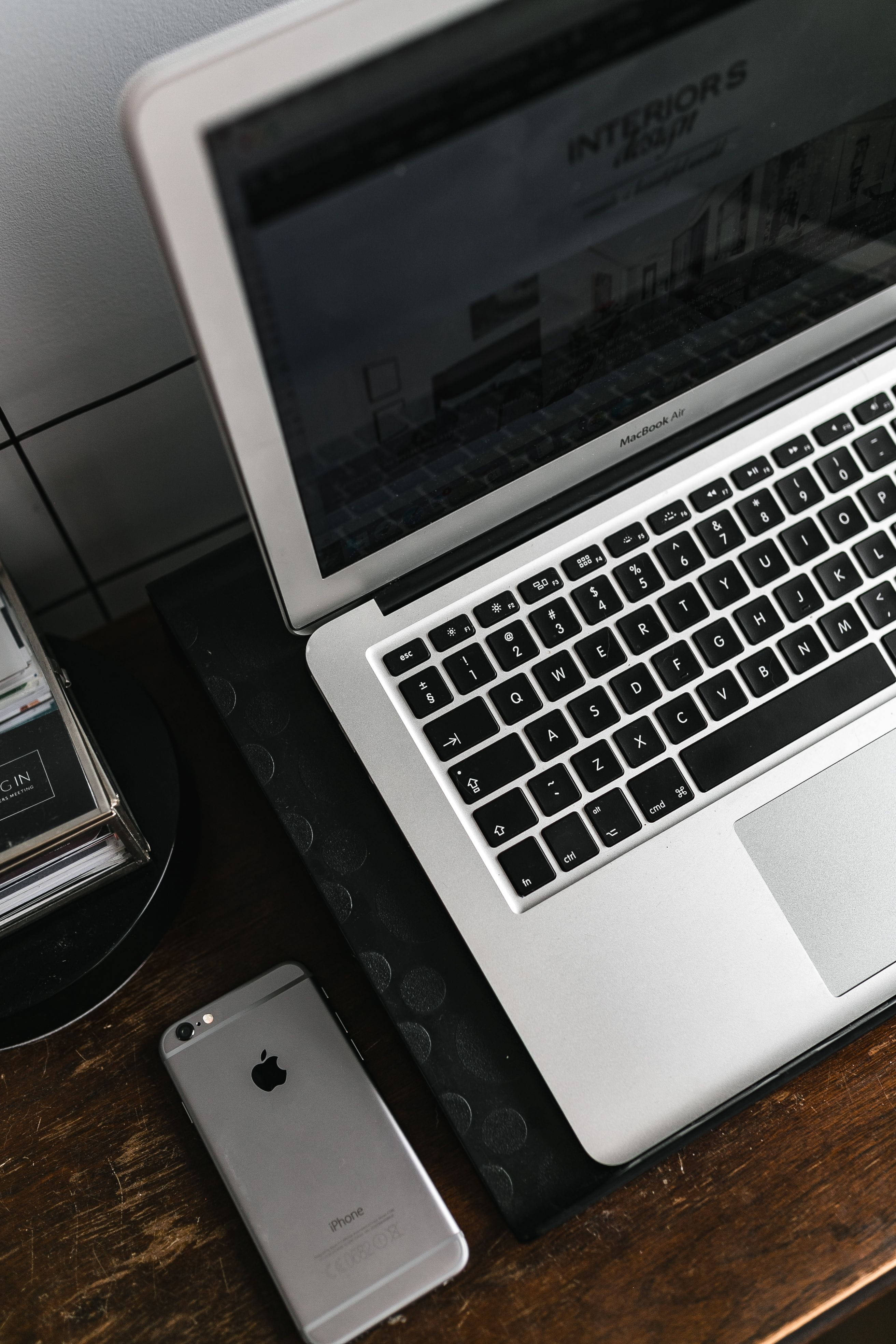 iPhone pe birou cu MacBook argintiu Fundal