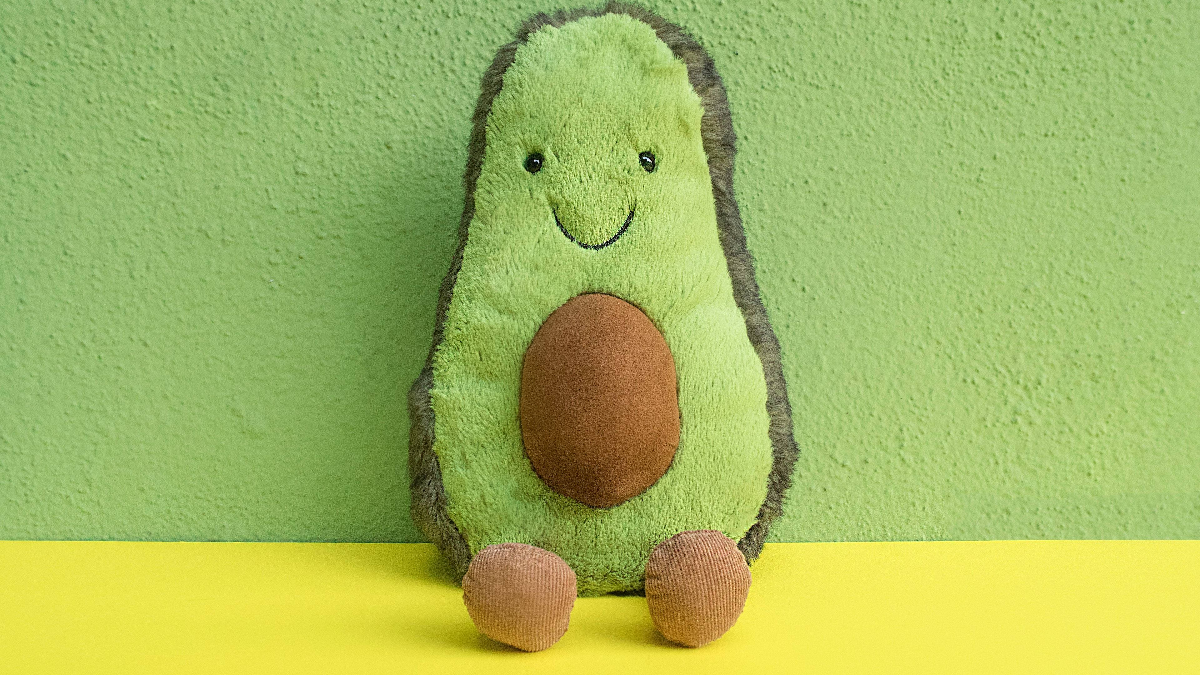 Jucărie de plus avocado pe fundal verde pastel Fundal