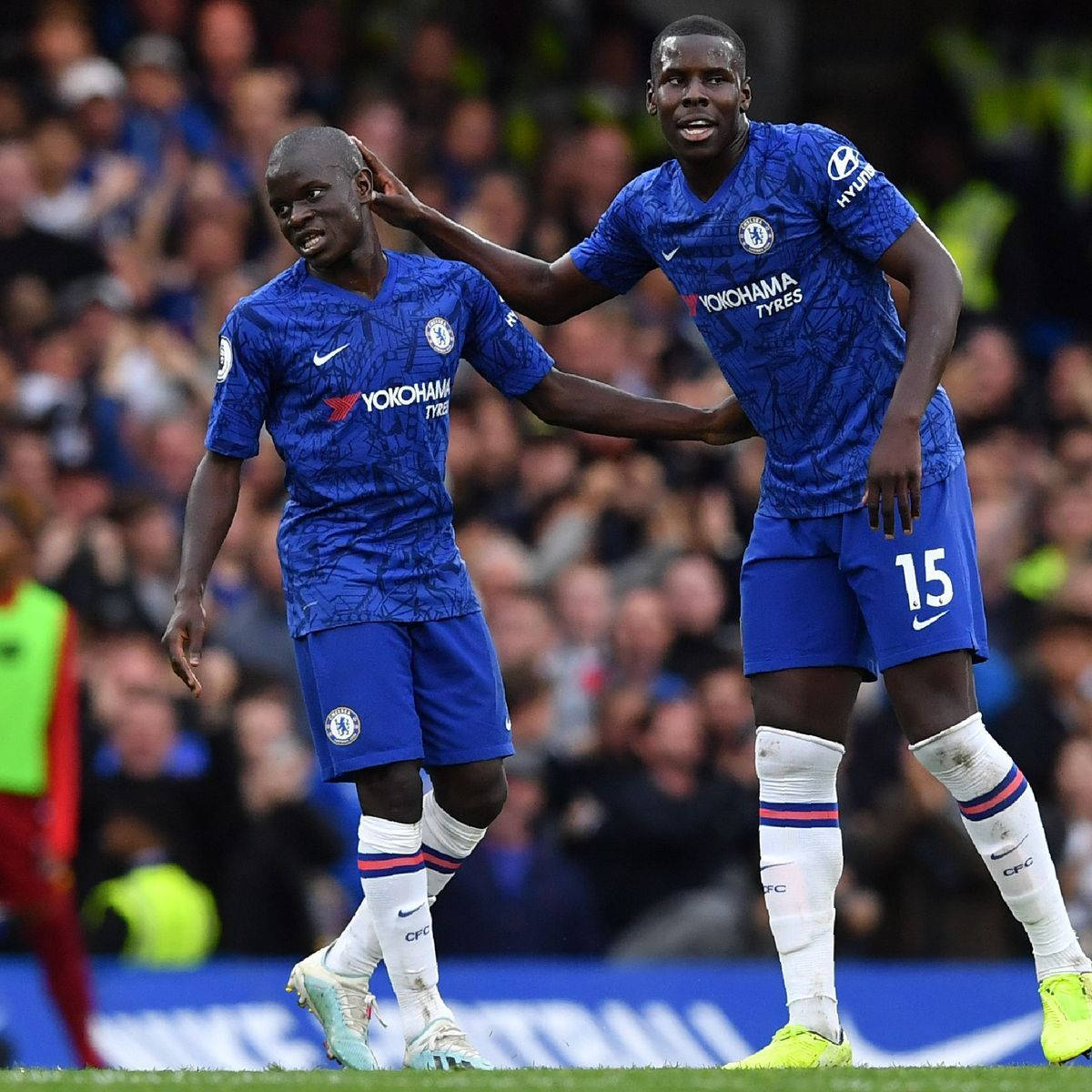 Kurt Zouma Atingând Capul Colegului de Echipă Fundal