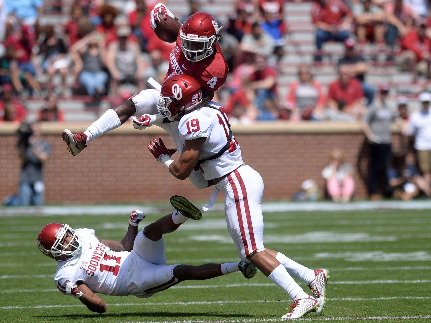 Kyler Murray sărind peste colegi Fundal