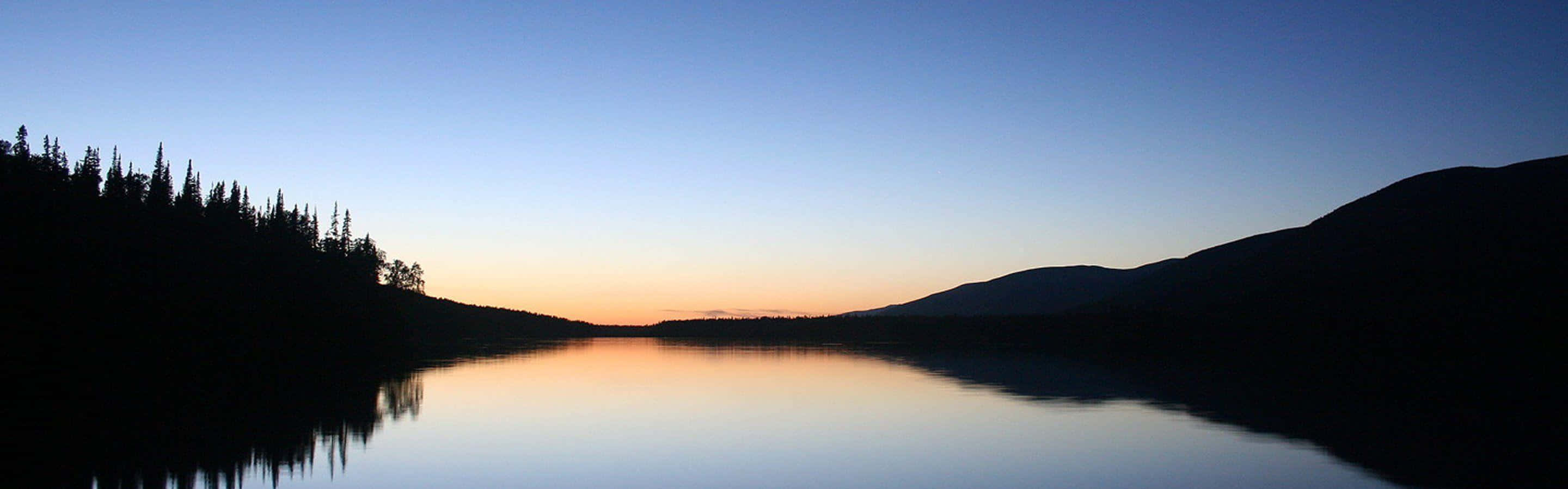 Lac liniștit la apus pe mai multe monitoare Fundal