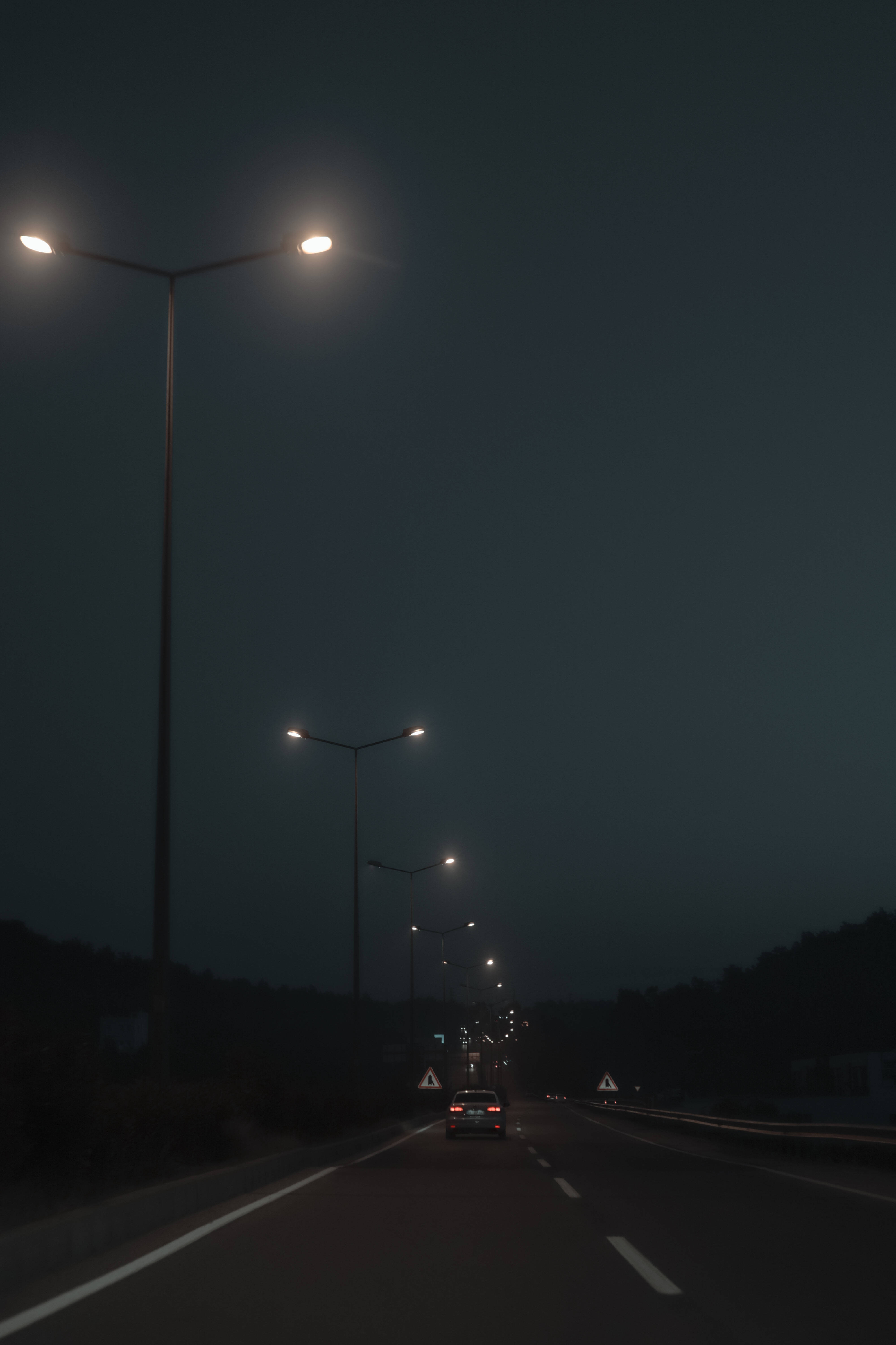Lampadare vechi lângă drum într-o seară întunecată Fundal