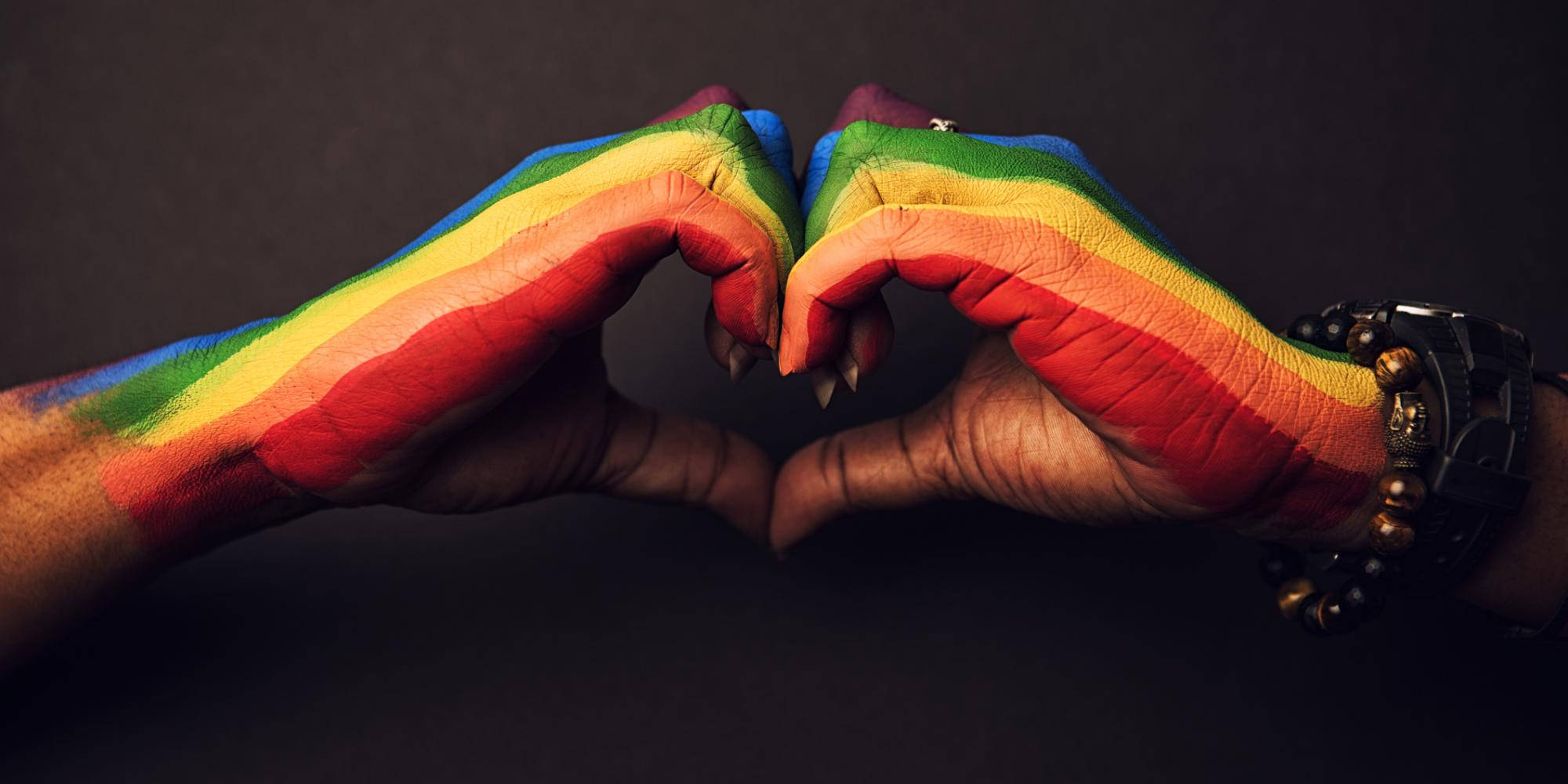 Mâna care formează o inimă susținând Love Is Love Fundal
