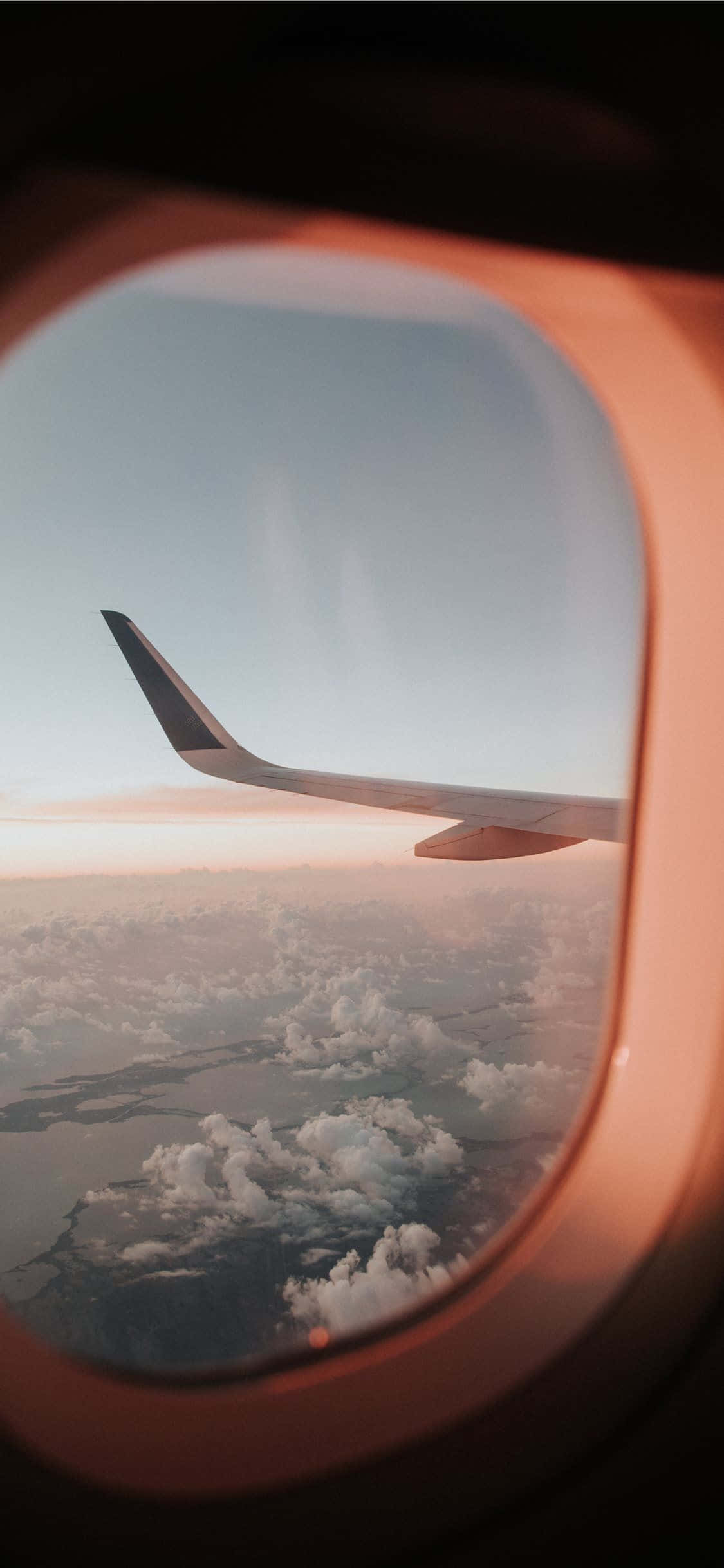 o aripă de avion văzută prin fereastra avionului Fundal