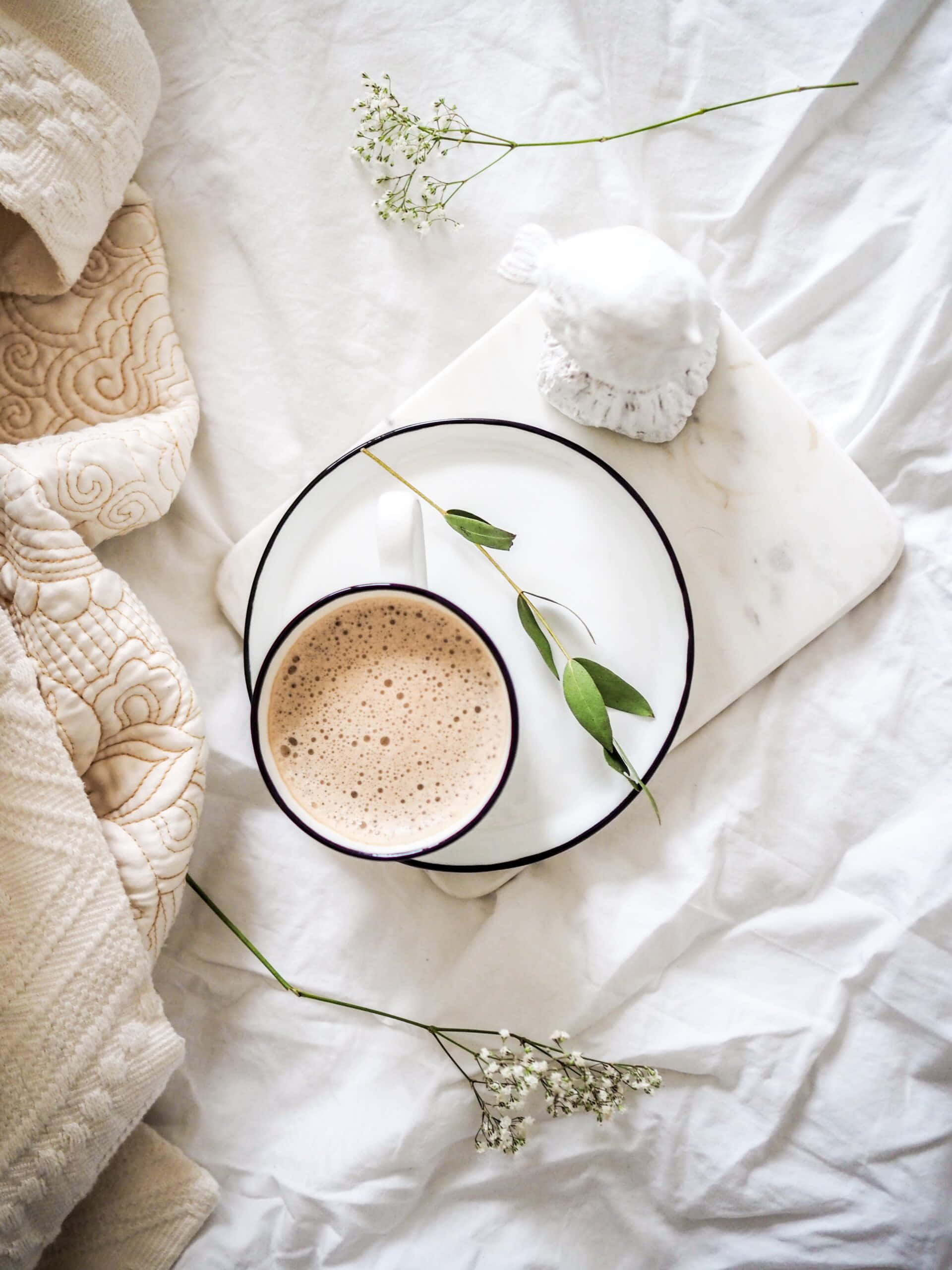 o ceașcă de cafea pe un pat cu flori Fundal