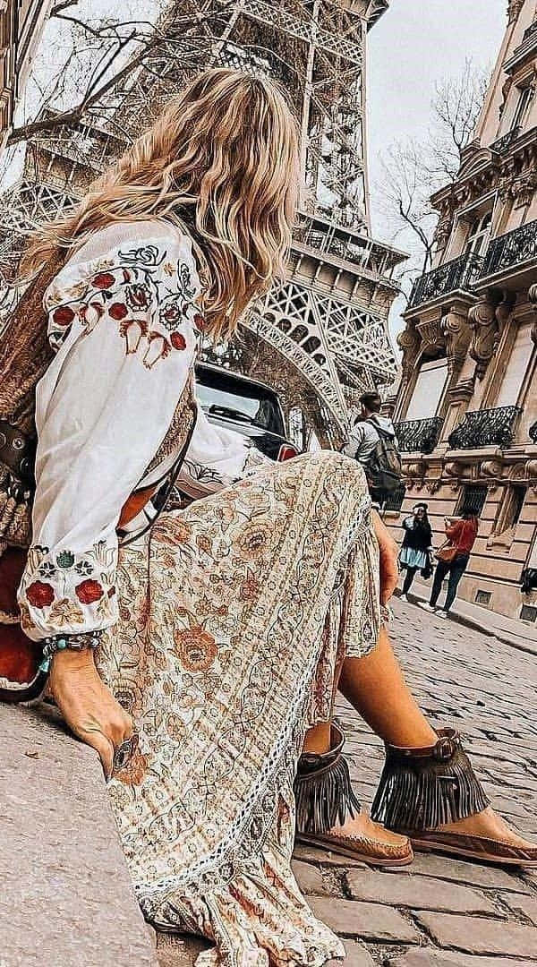 o femeie stând pe treptele Turnului Eiffel Fundal