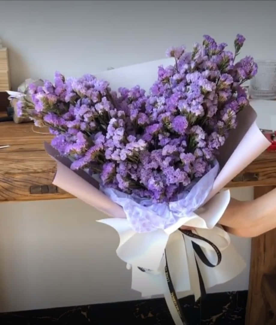 o femeie ținând un buchet de flori violet Fundal