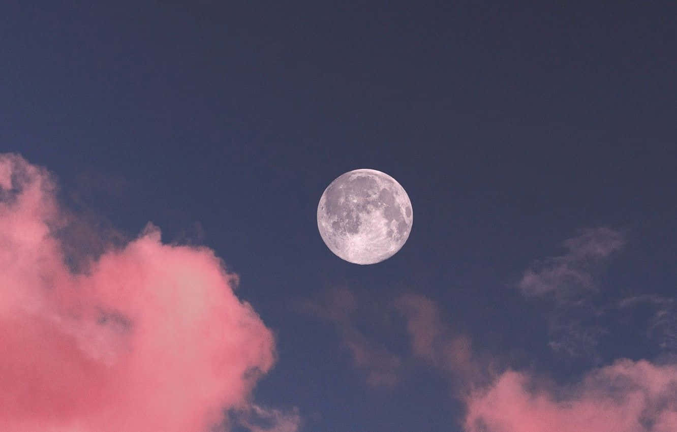 o lună roz cu nori pe cer Fundal