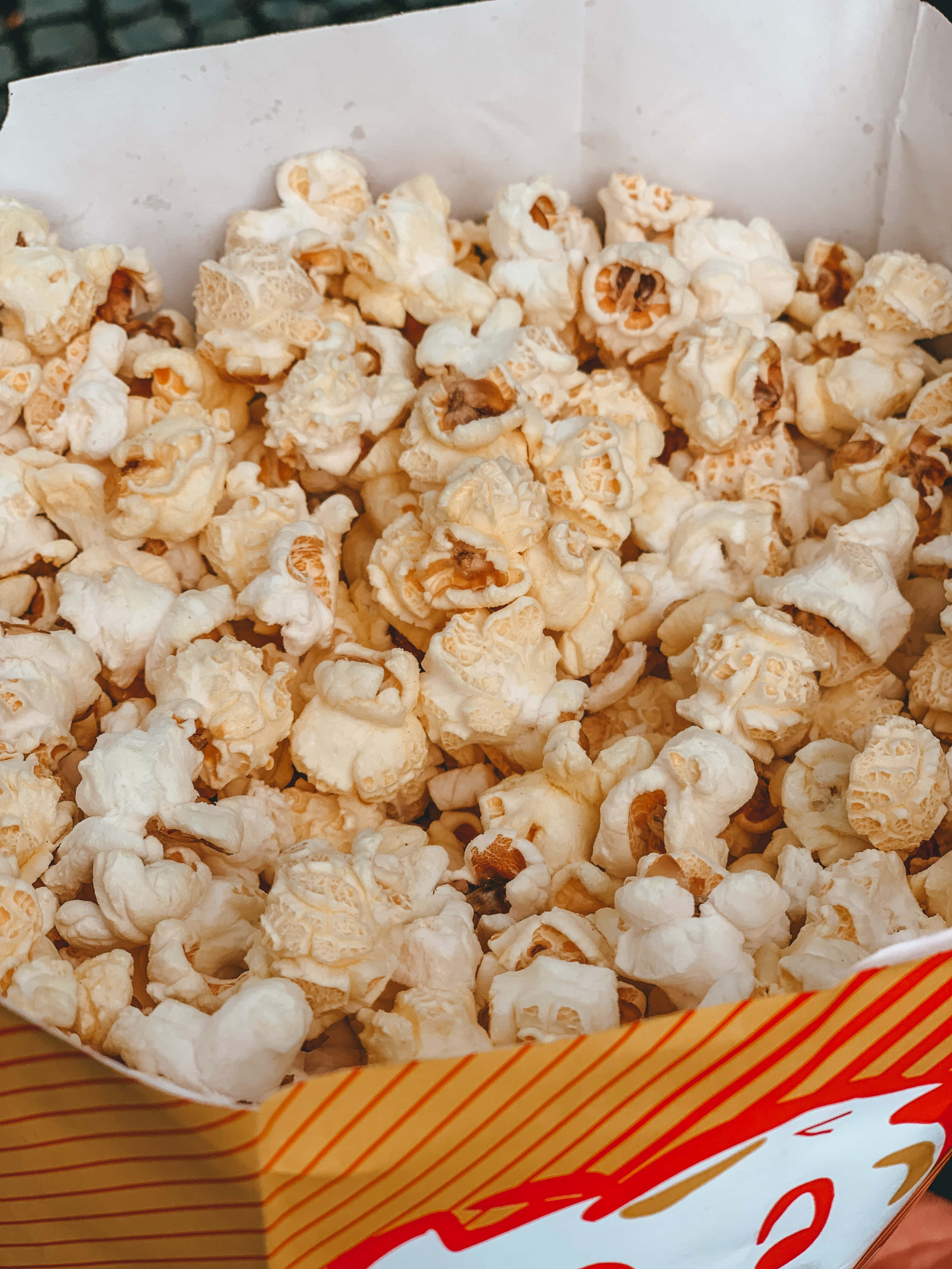 o persoană care ține o cutie de popcorn Fundal