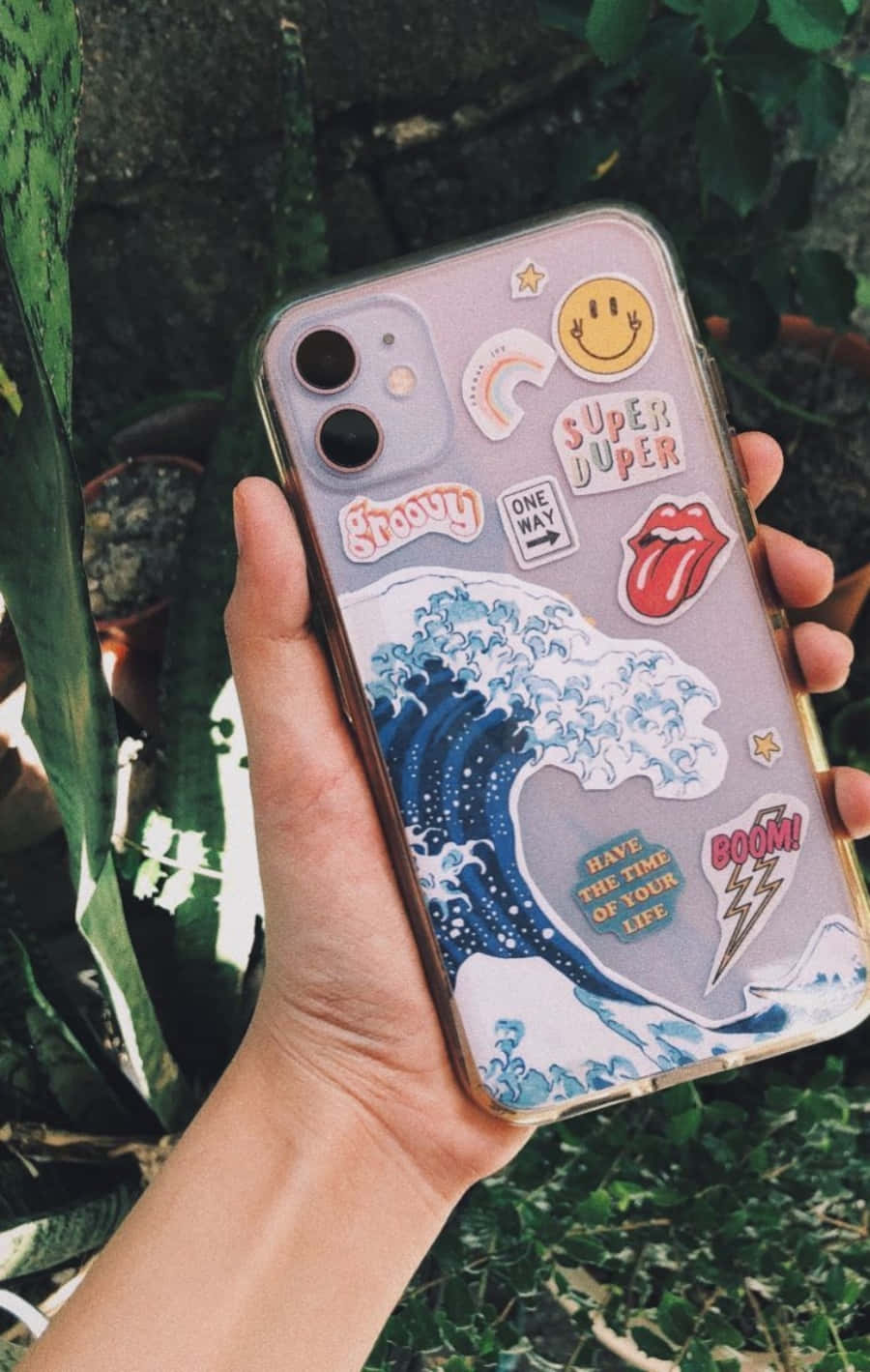o persoană care ține o husă de telefon cu abțibilduri pe ea Fundal
