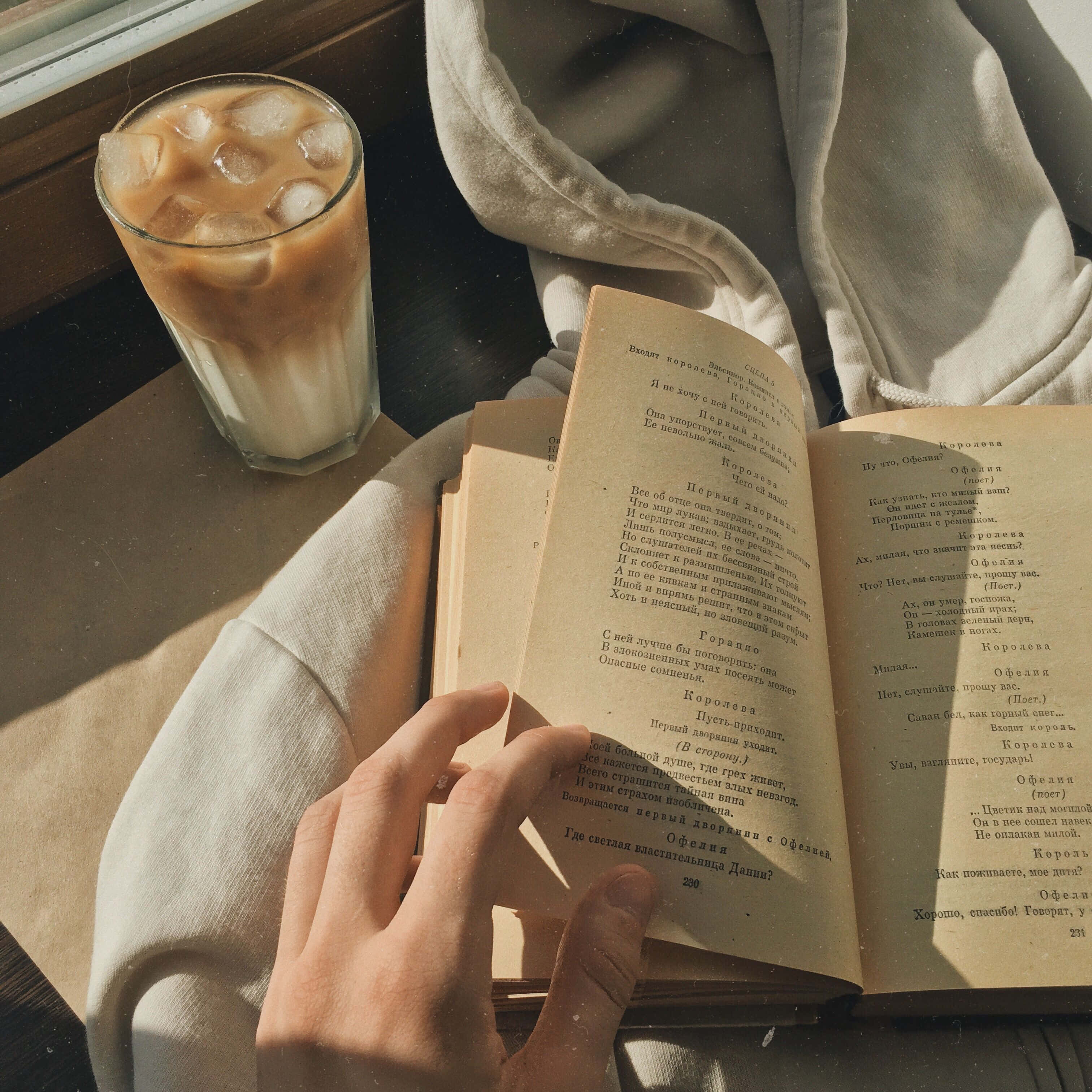 o persoană citind o carte cu o ceașcă de cafea Fundal