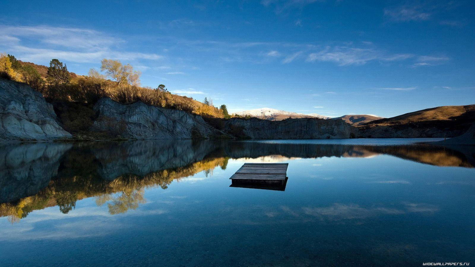 O potecă rustică din scânduri de lemn înconjurată de natură luxuriantă Fundal