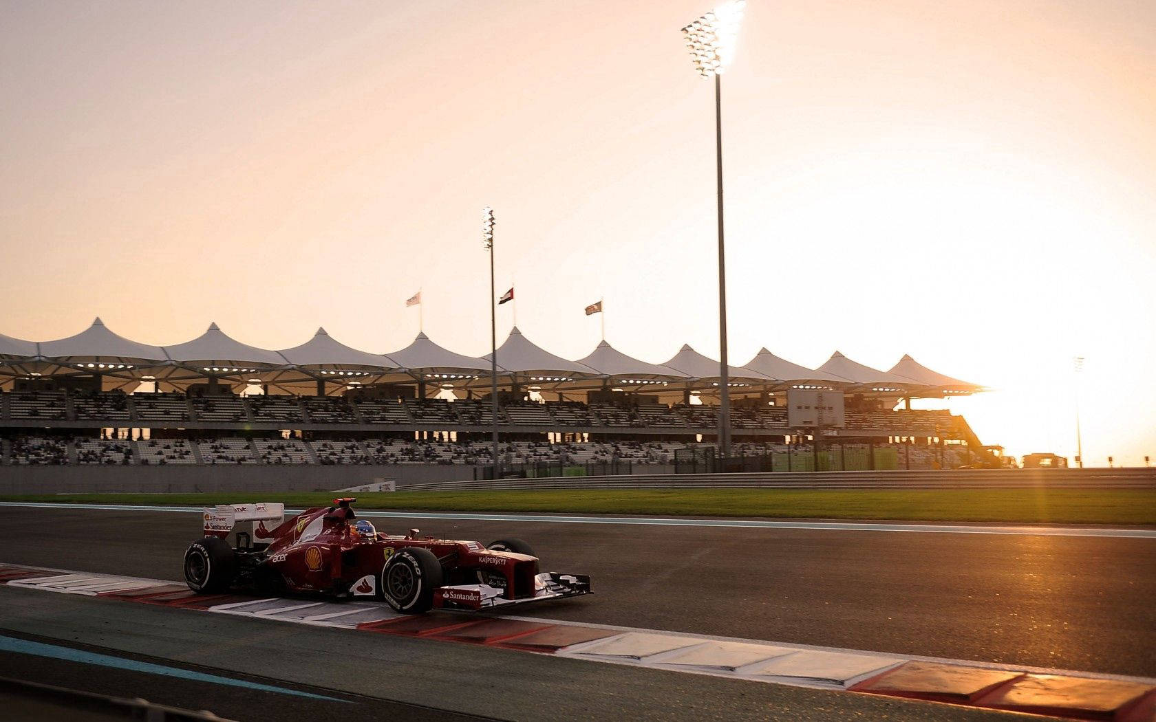 O vedere dinamică a unei mașini Ferrari de Formula Unu pe pistă Fundal