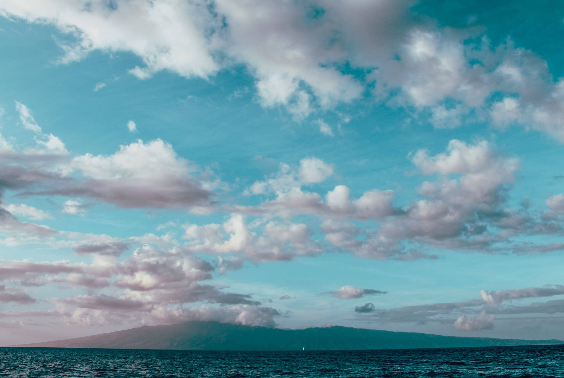 Ocean albastru deschis cu cer înnorat Fundal