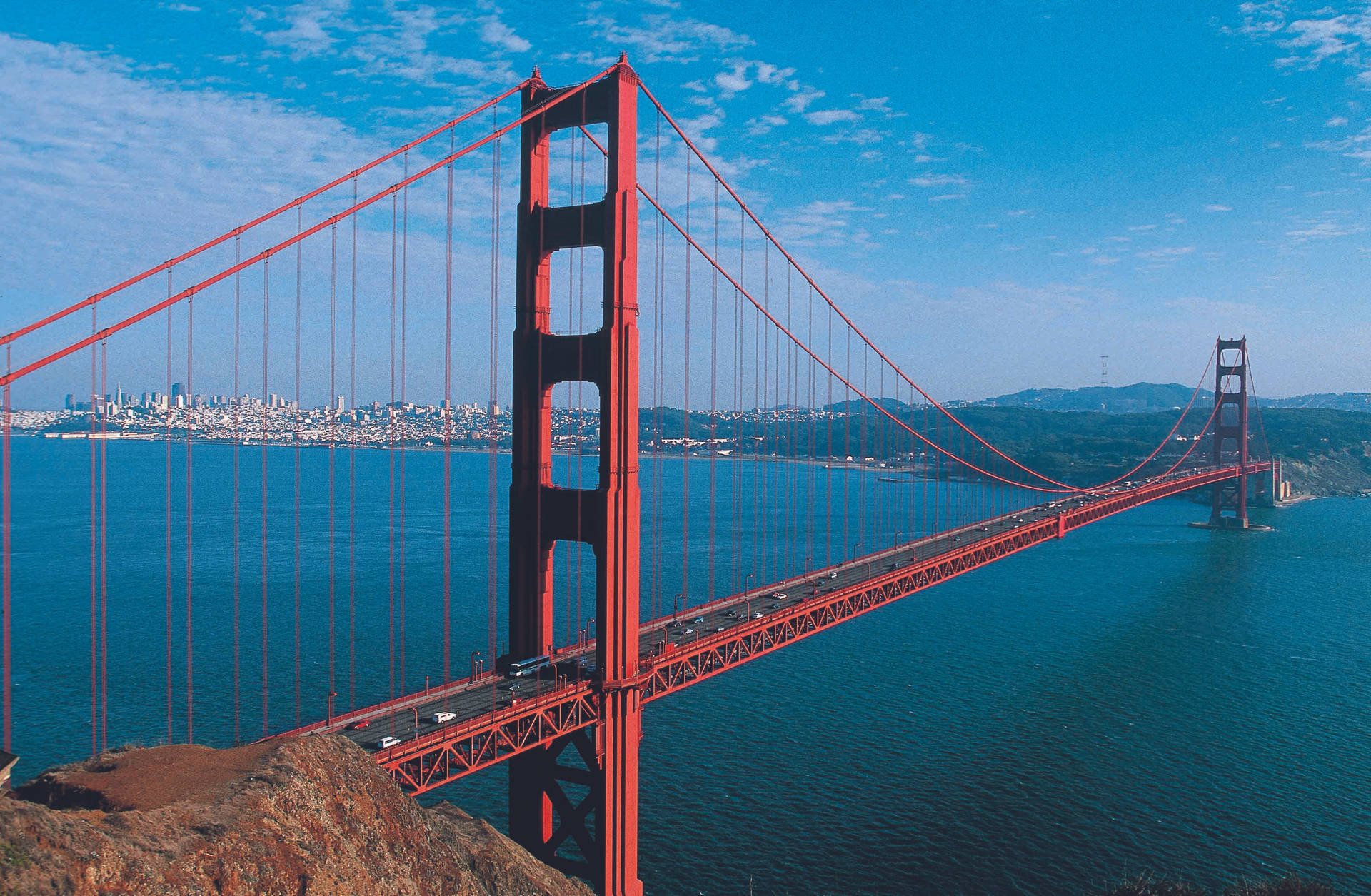 Podul Golden Gate suspendat deasupra apei albastre Fundal
