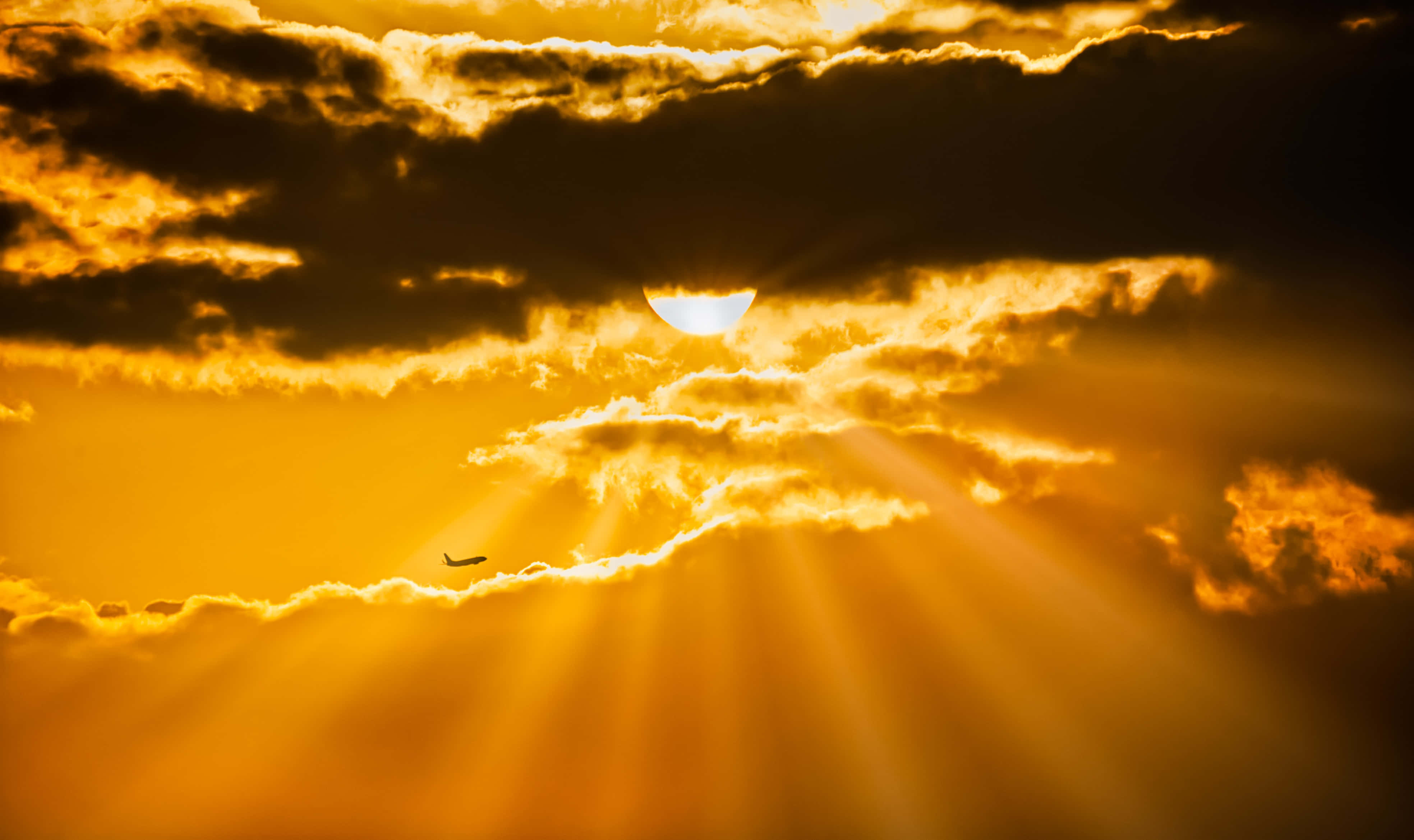 Raze de soare majestuoso iluminând un cer auriu Fundal