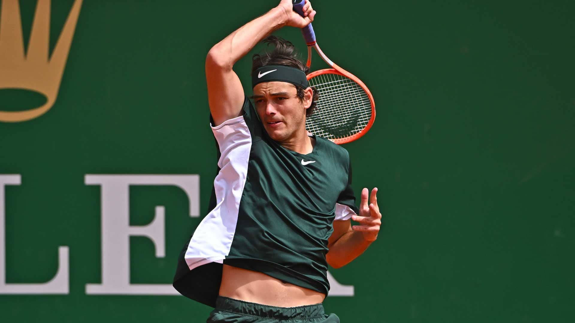 Taylor Fritz în Acțiune - Smash Puternic de Deasupra Capului Fundal