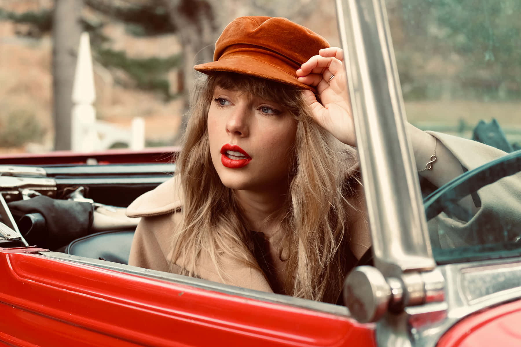 Taylor într-o mașină decapotabilă roșie din Red Taylors Version Fundal