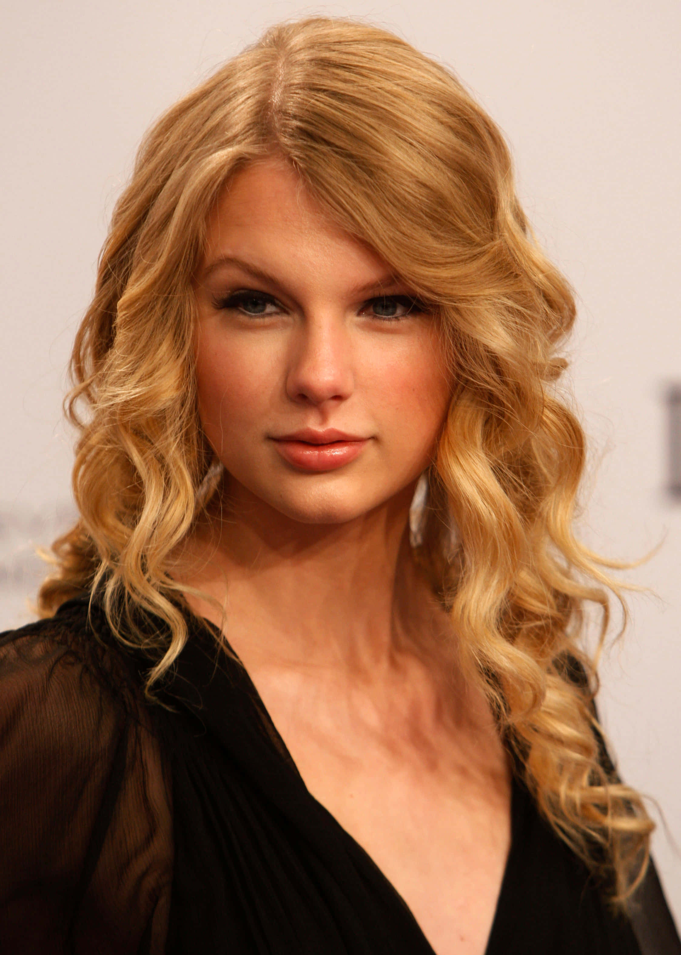 Taylor Swift cântând pe scenă în timpul unui concert Fundal