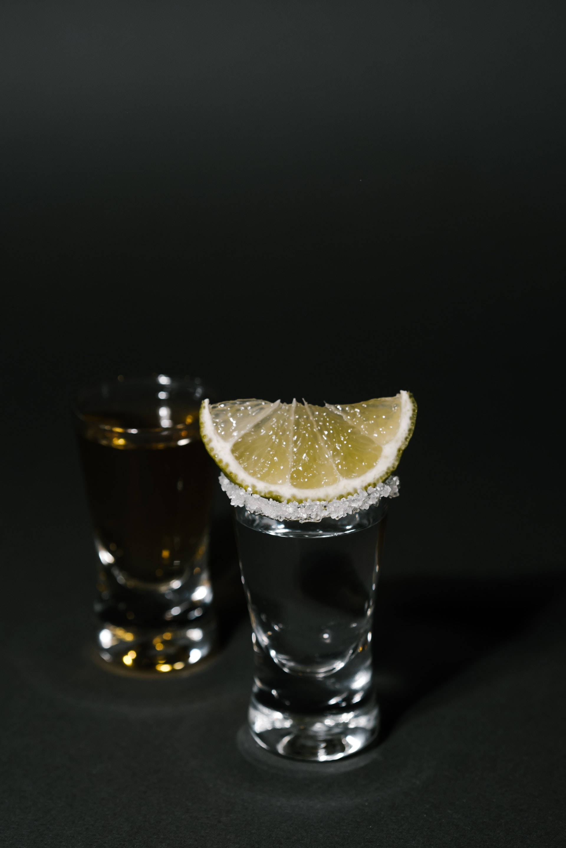 Tequlă argintie și aurie cu shots de lămâie Fundal