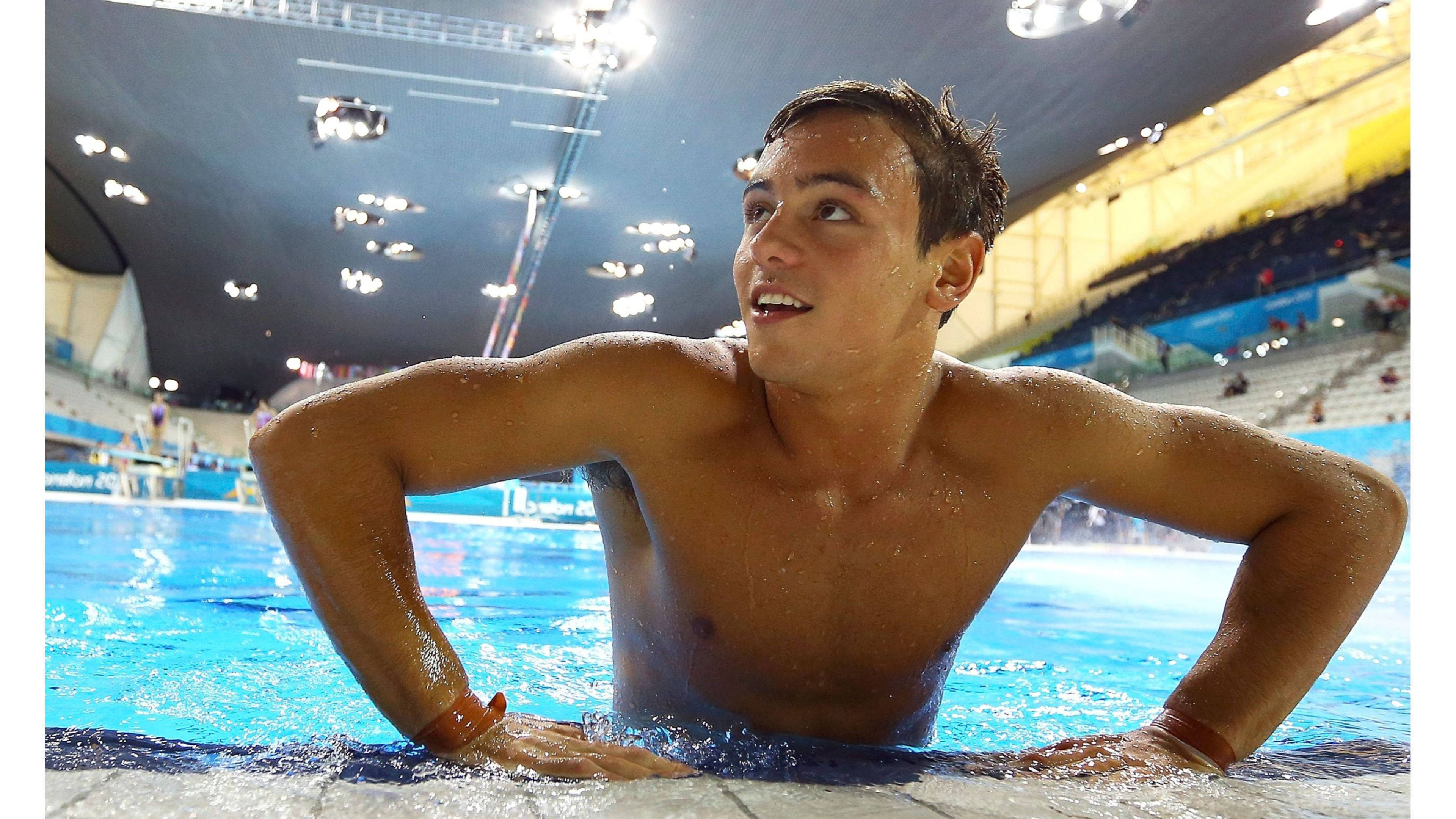 Tom Daley se pregătește pentru un salt lângă piscină. Fundal