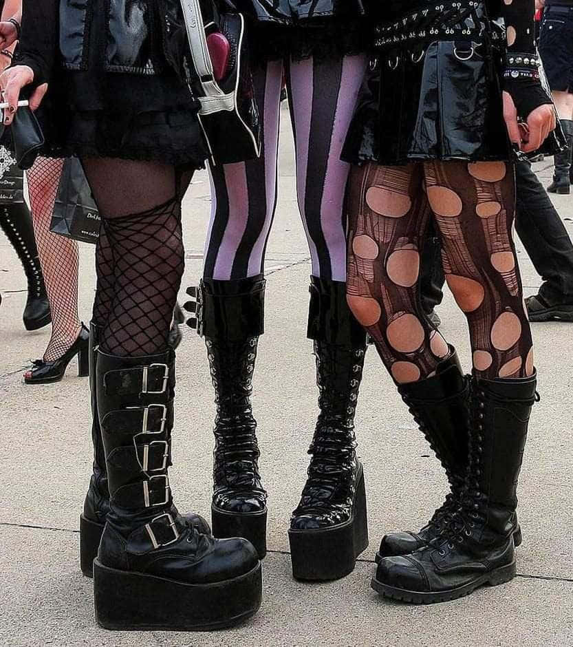 trei femei în ținute gothice stând împreună Fundal