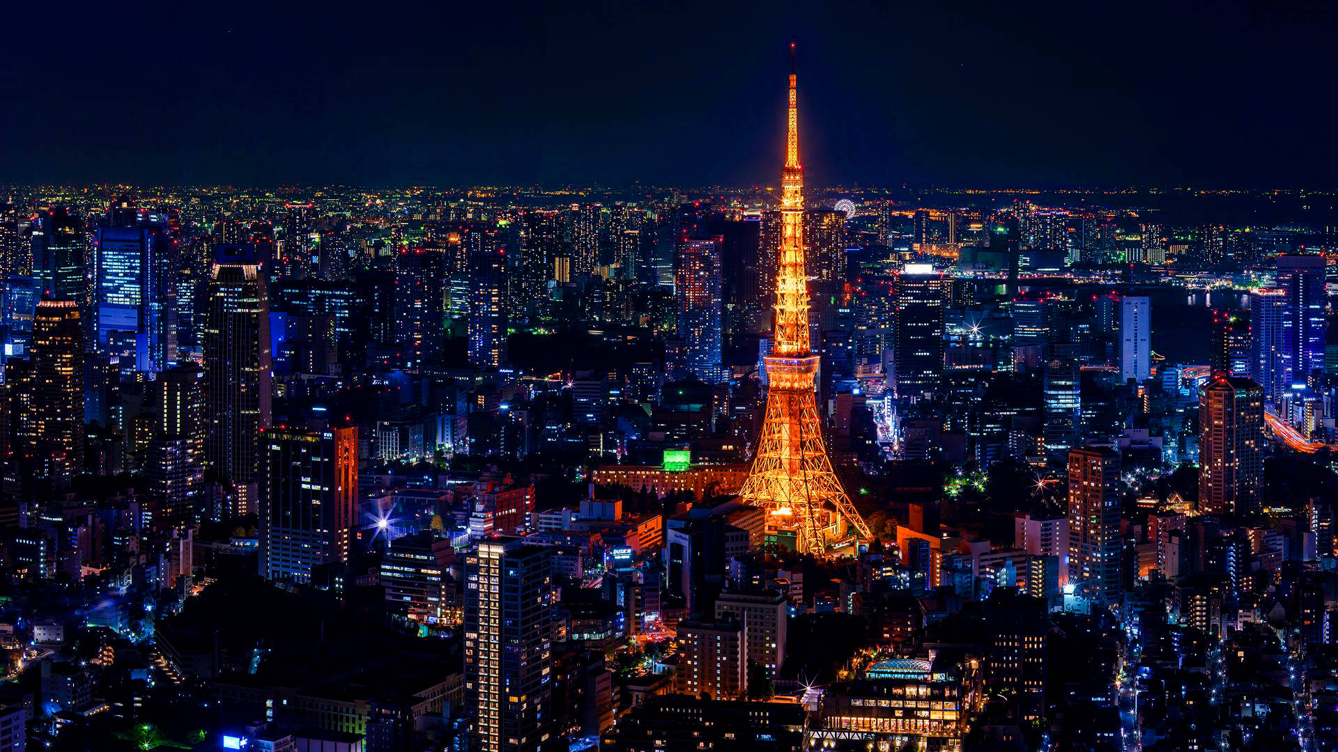 Turnul Tokyo Auriu cu Lumini Colorate ale Orașului Fundal