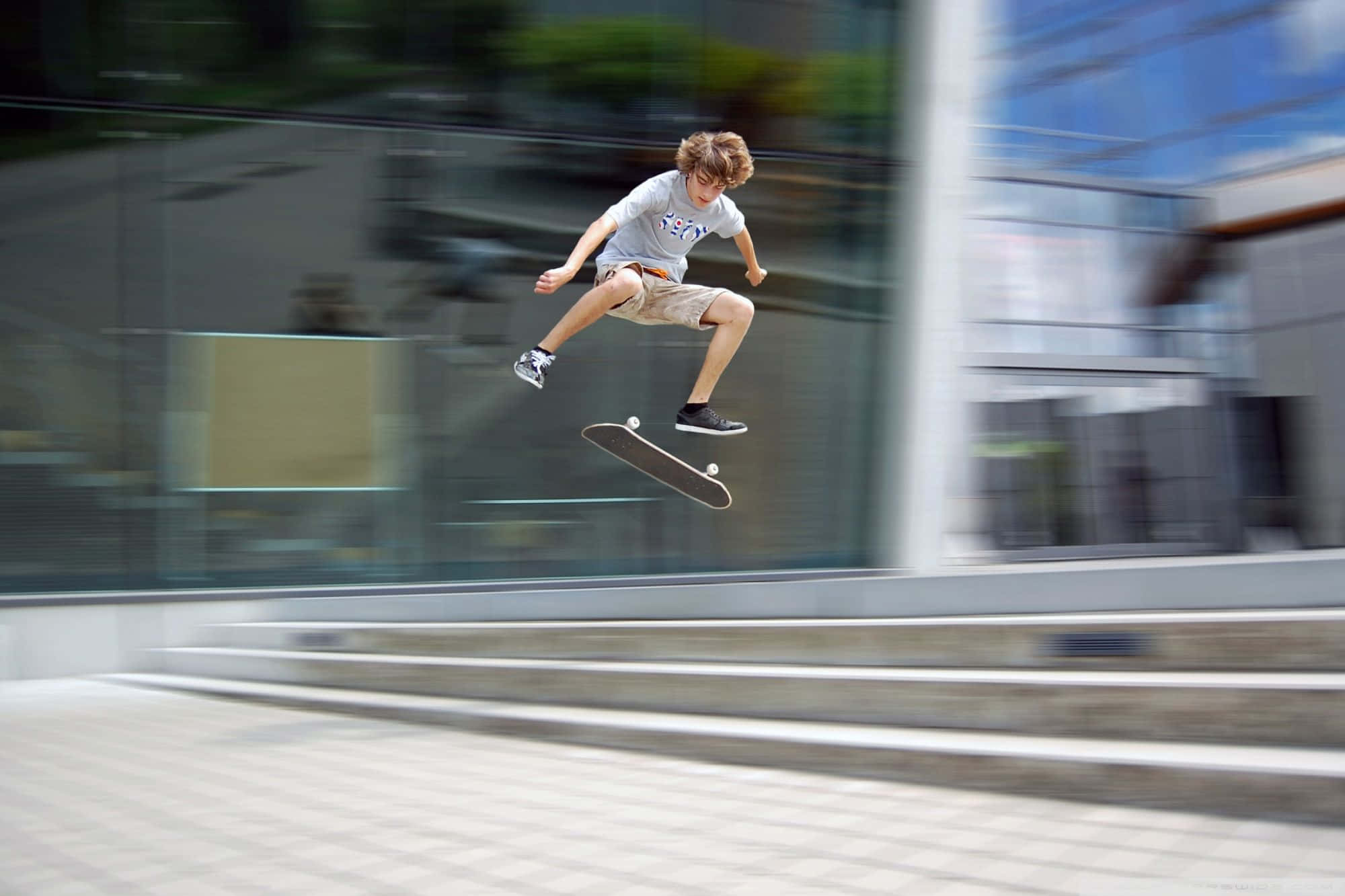 un băiat execută o figură de skateboard Fundal