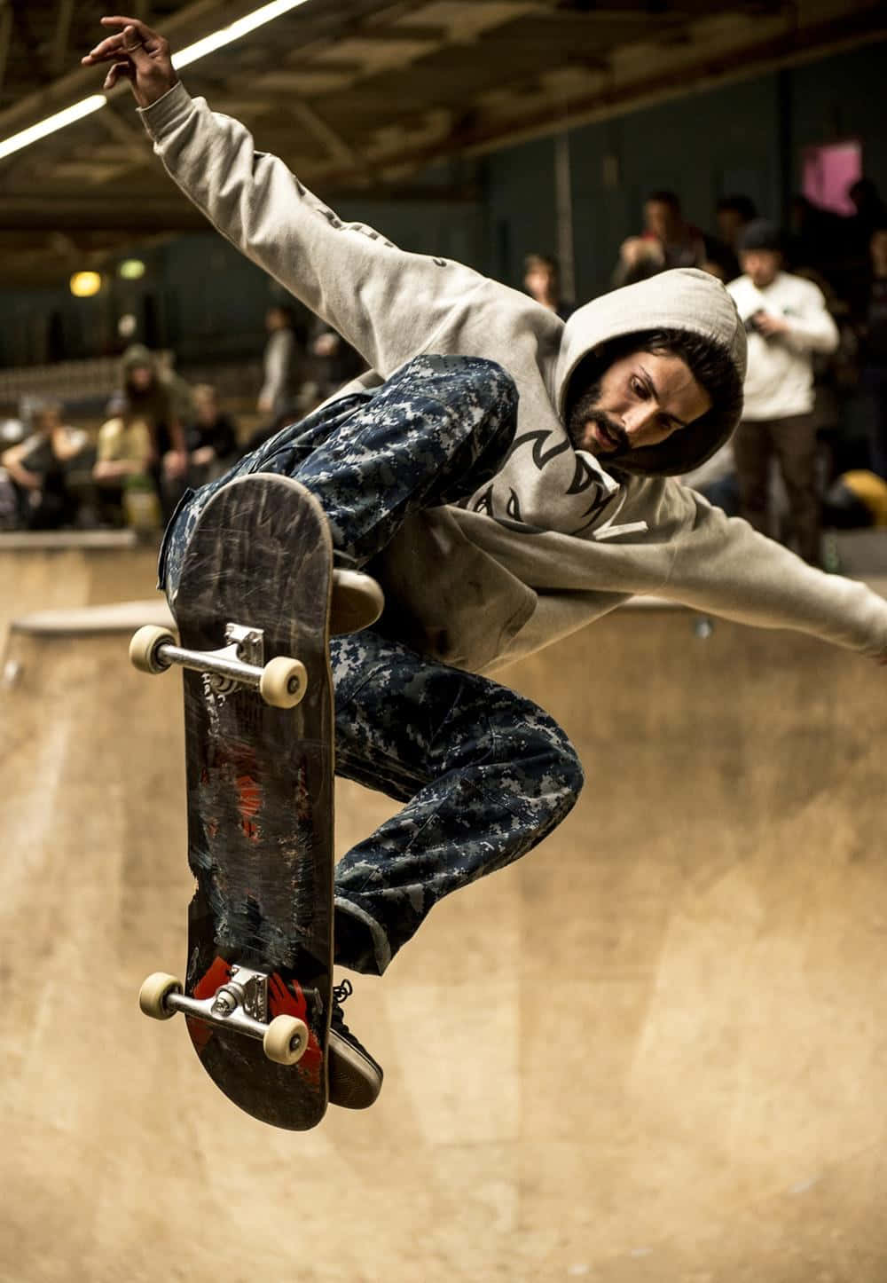 un bărbat în hanorac făcând un trick de skateboard Fundal