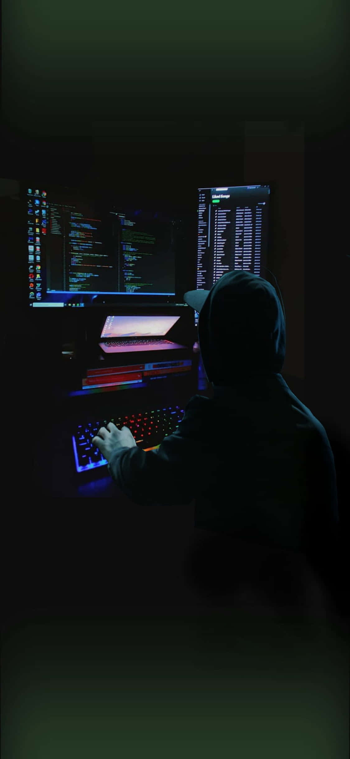 un bărbat stă la un computer în întuneric Fundal