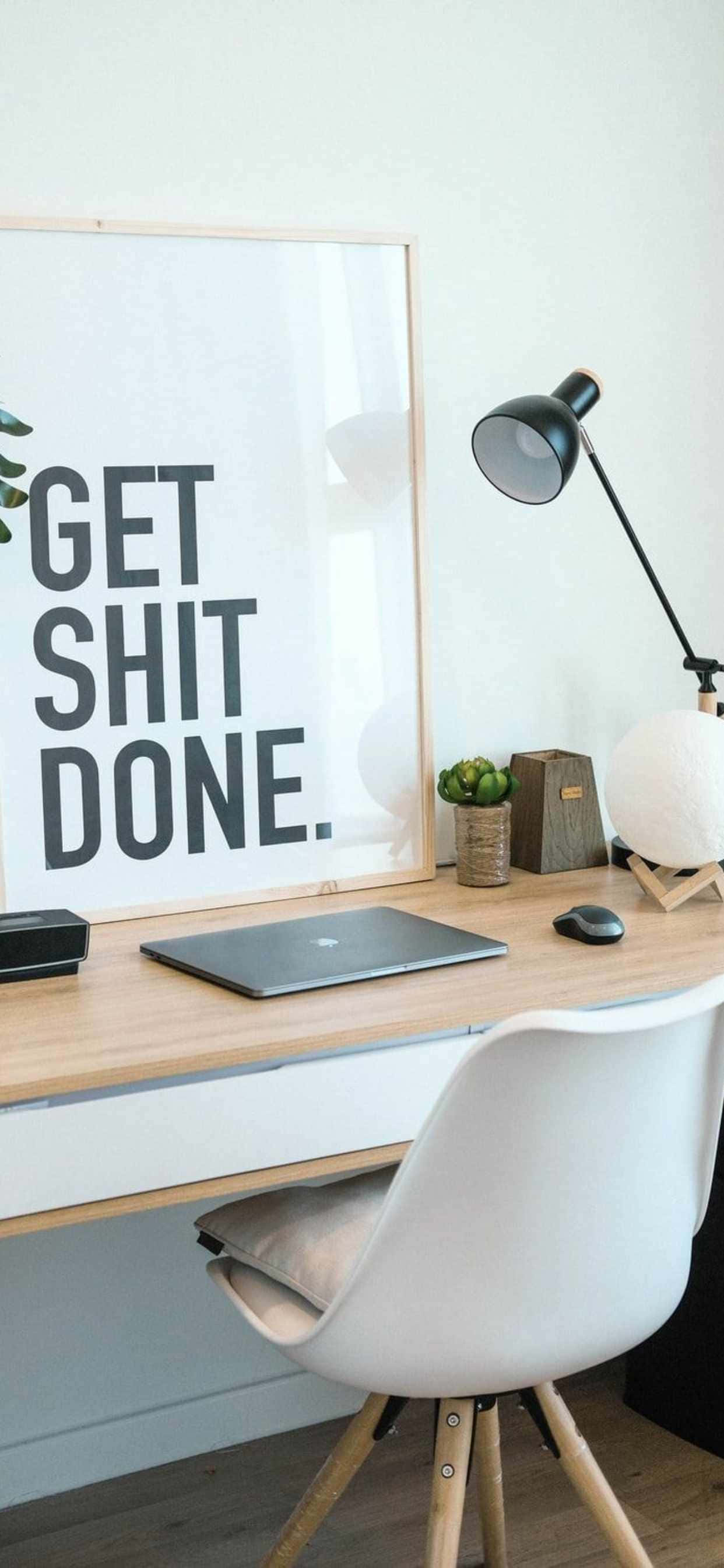 un birou cu un poster pe care scrie „get shit done” Fundal