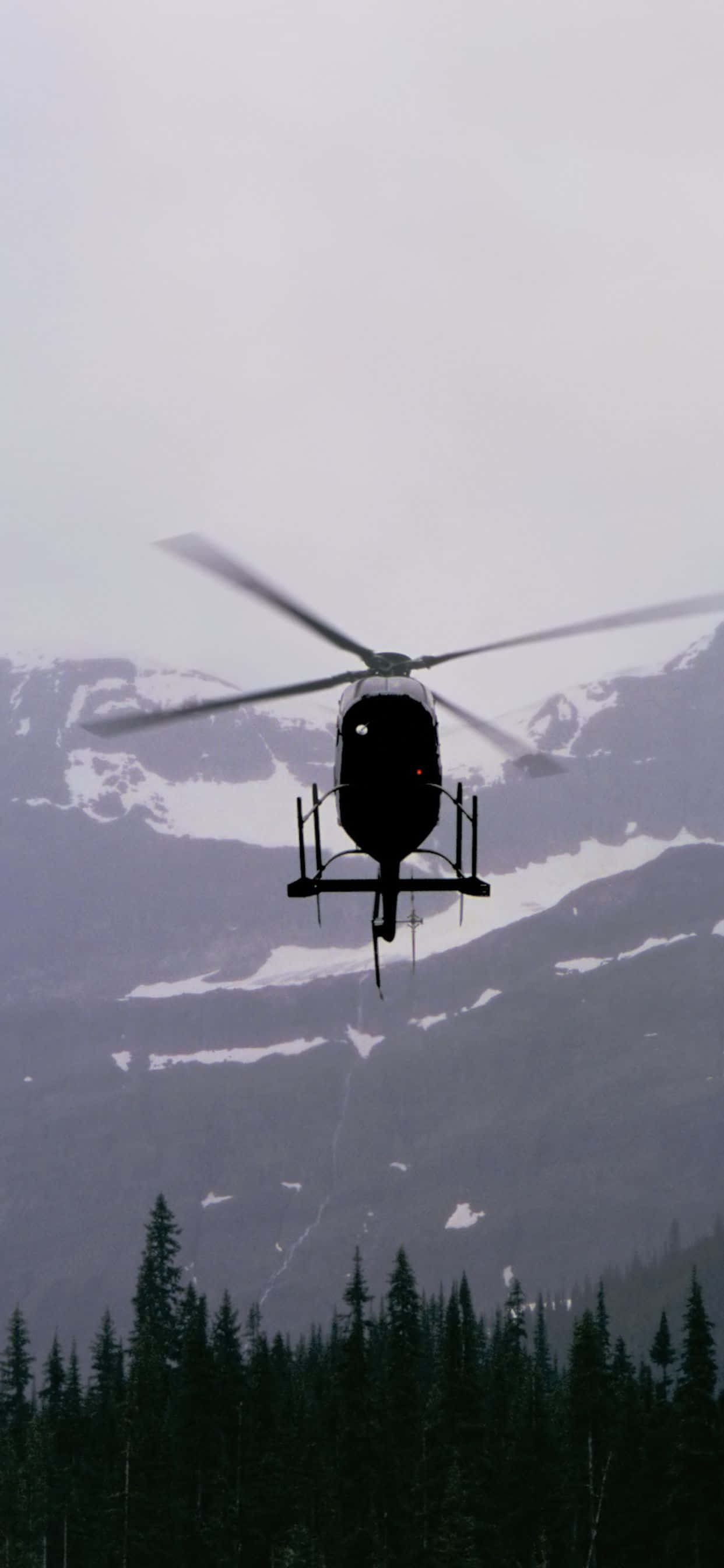 un elicopter zburând deasupra unui lanț muntelui Fundal