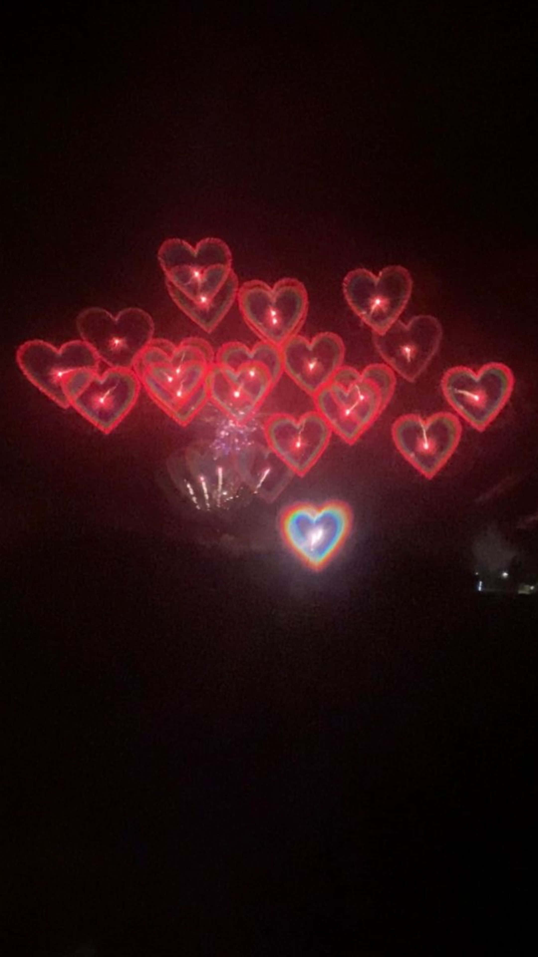 un foc de artificii în formă de inimă în întuneric Fundal
