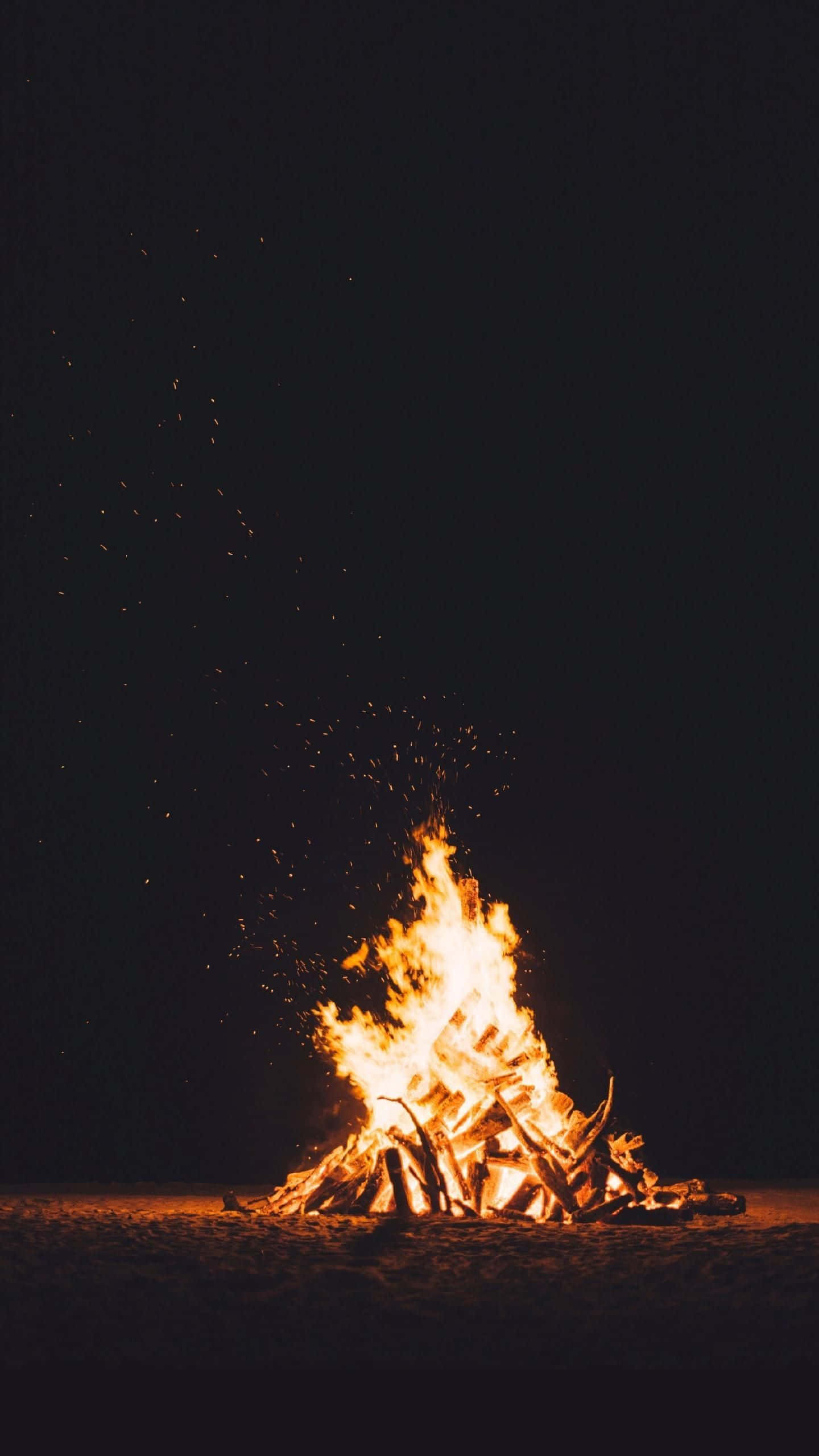 un foc de tabără pe plajă noaptea Fundal